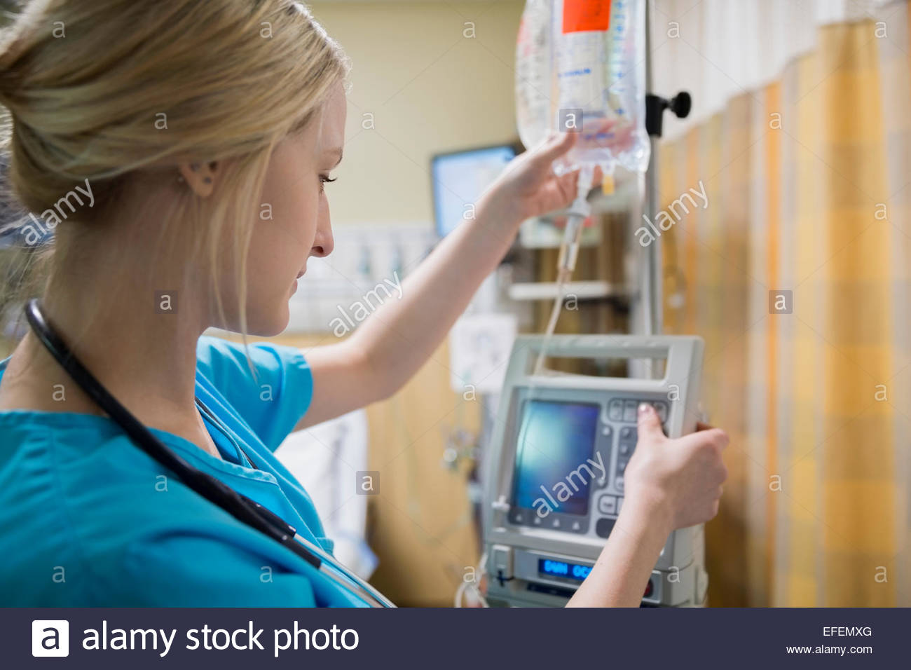 Enfermera de perfusión IV de conexión a la máquina en el hospital Foto de stock