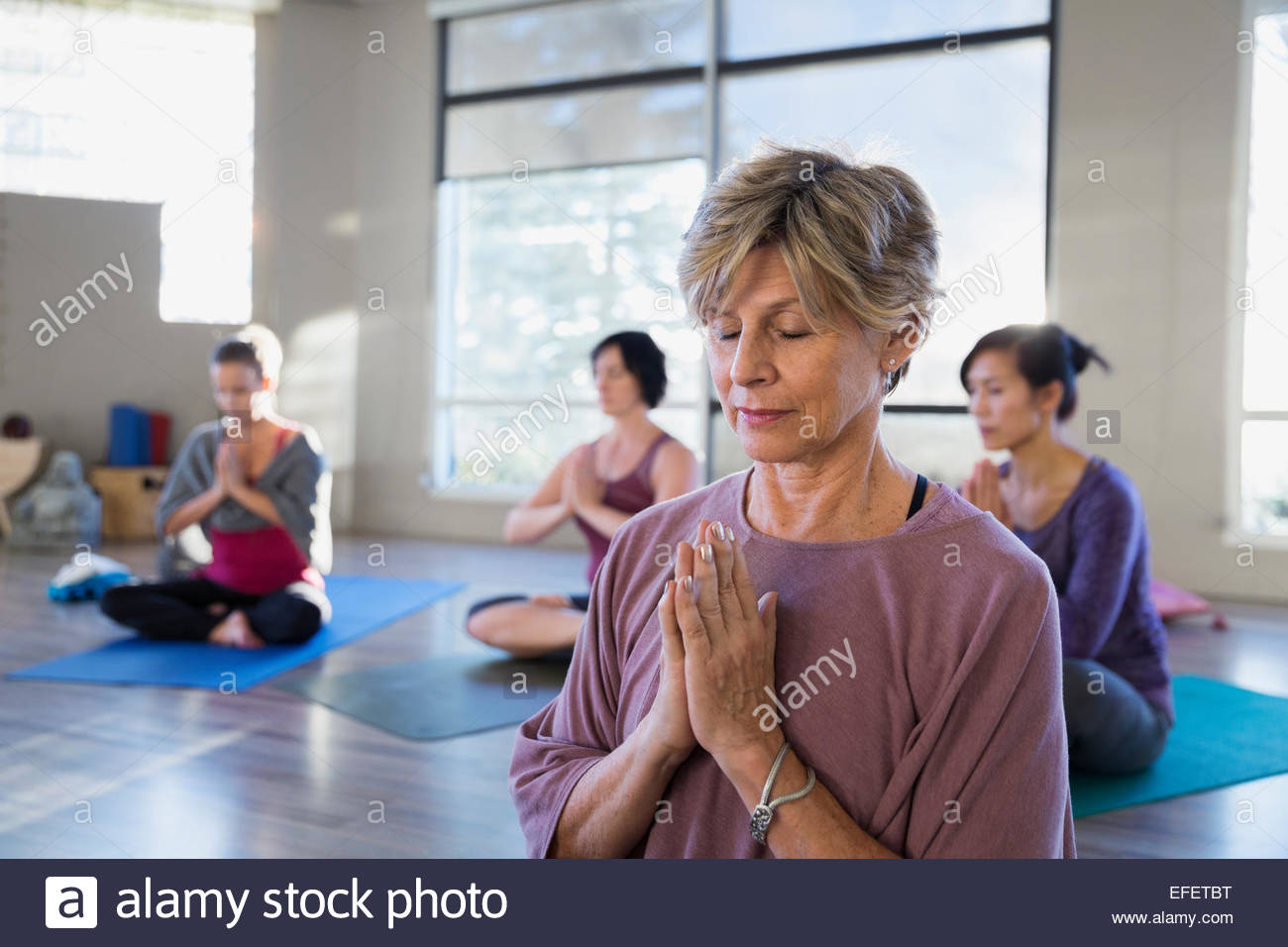 Serena mujer meditando en clase de yoga Foto de stock
