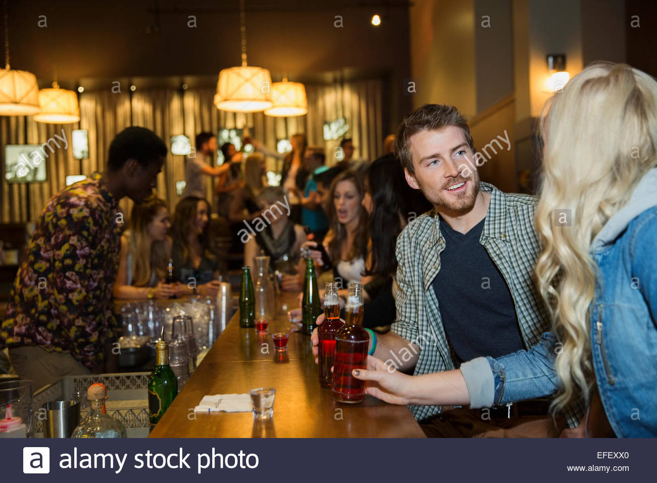 Par hablar y beber en el bar Foto de stock