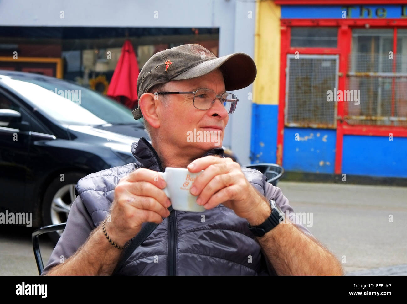 Un varón de mediana edad disfruta de un café en un café al aire libre wine bar en West Cork Ireland Foto de stock