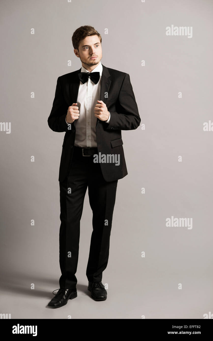 Retrato de joven hombre vestido con traje negro, camisa blanca y arco  Fotografía de stock - Alamy