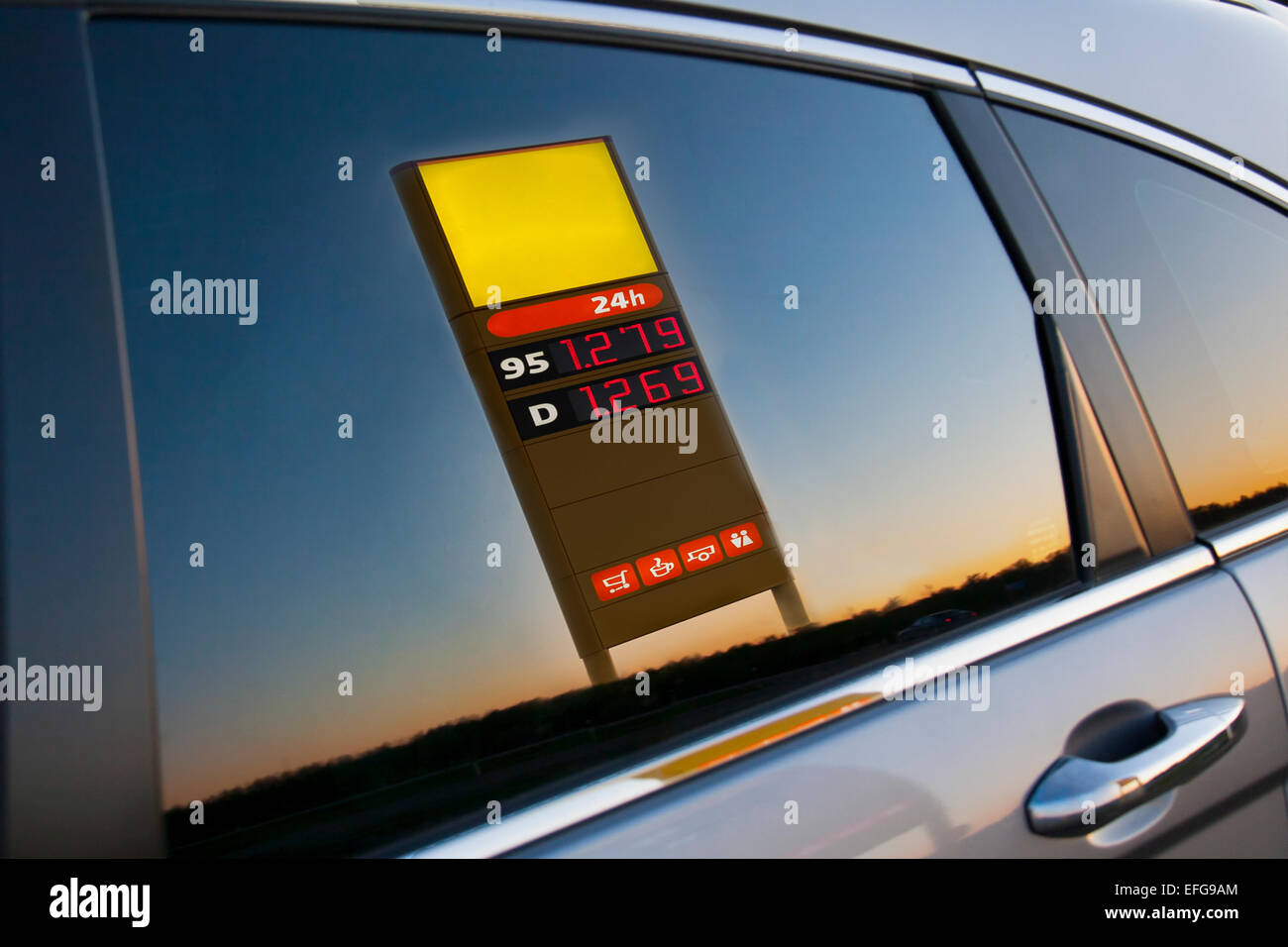 Gas, gasolinera precio post reflejo en coche cristal lateral. Puerta, closeup. Foto de stock