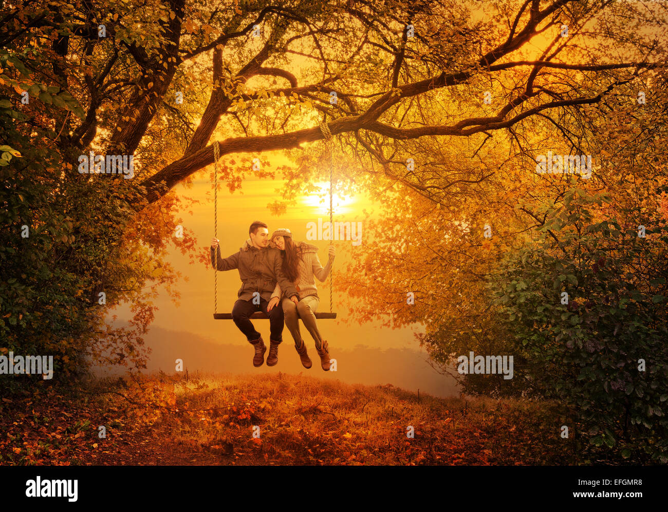 Pareja romántica columpio en el parque de otoño Foto de stock