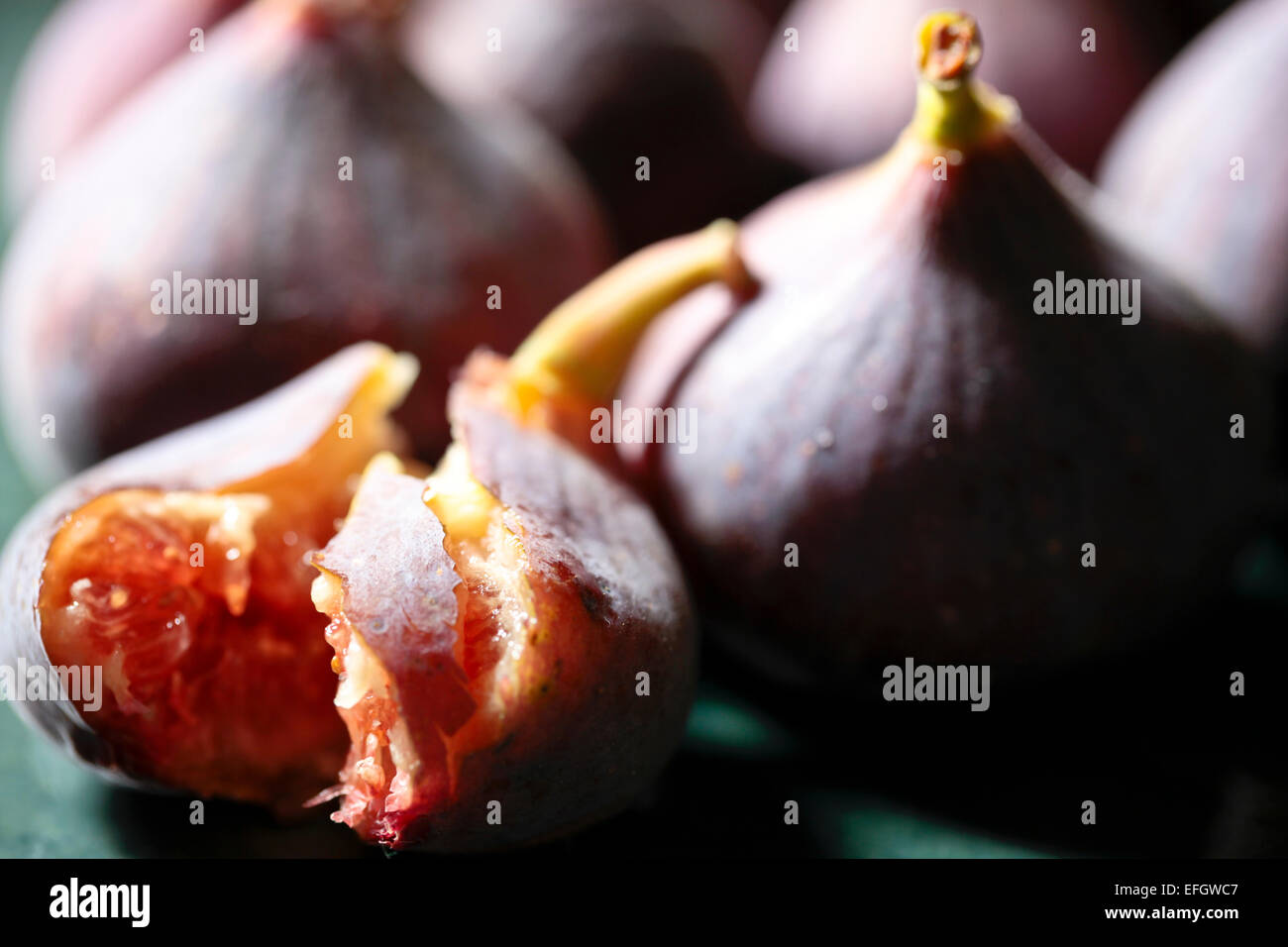 Cerca de higos con uno de sus frutos maduros mitad comido Foto de stock