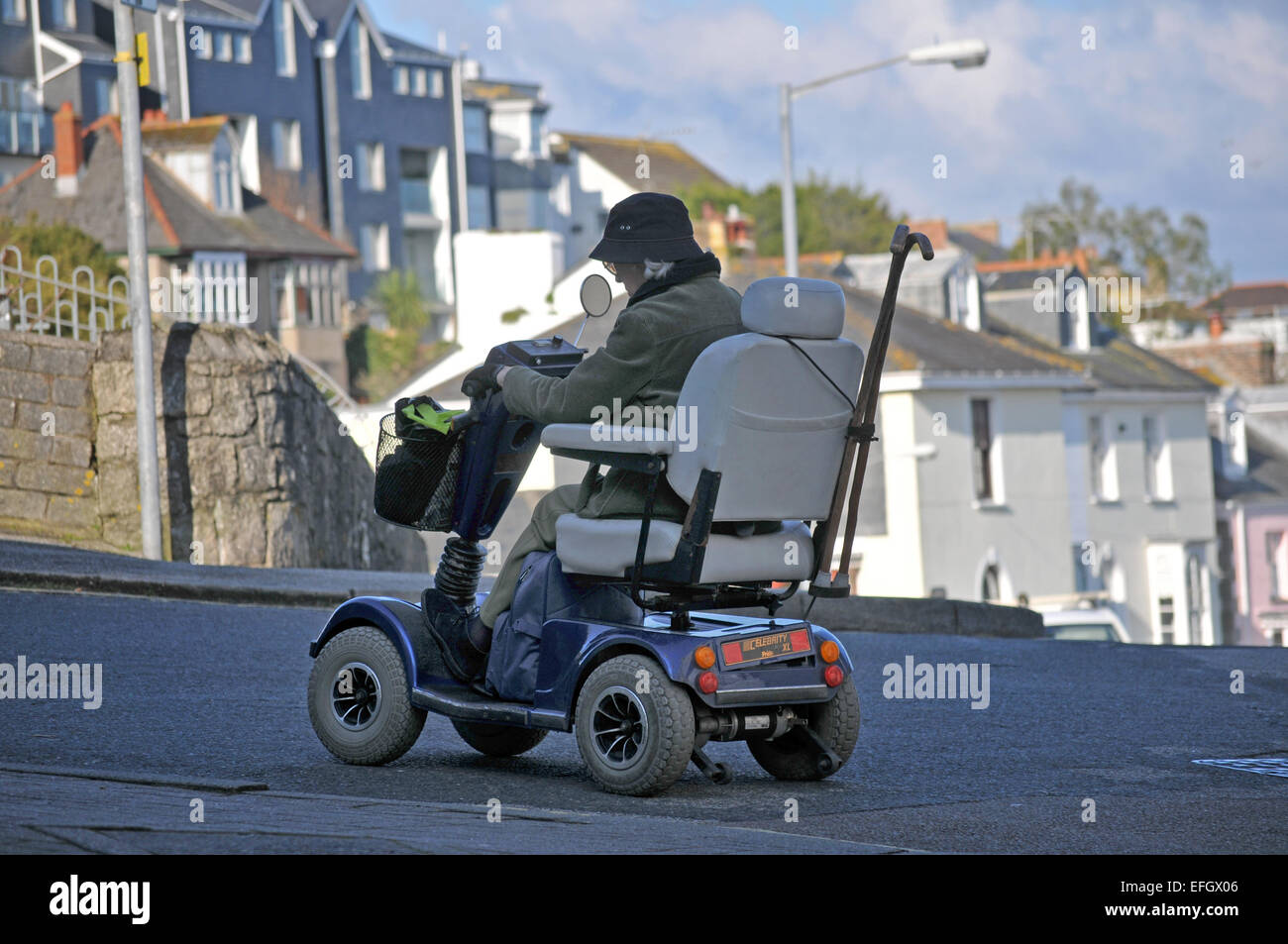 Una dama paseos su scooter de movilidad Foto de stock