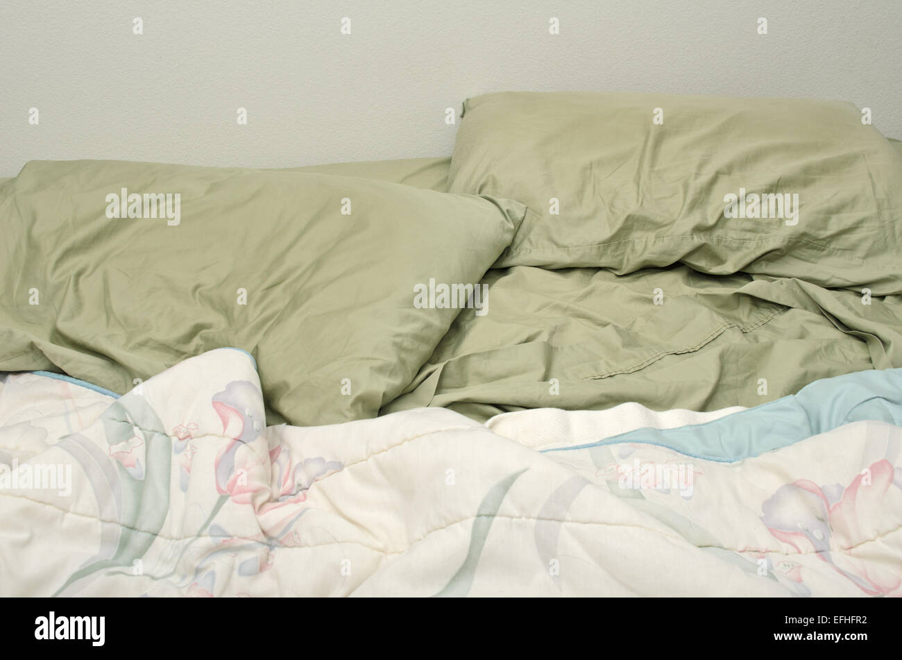 Desorden en la cama, almohadas y mantas. Foto de stock