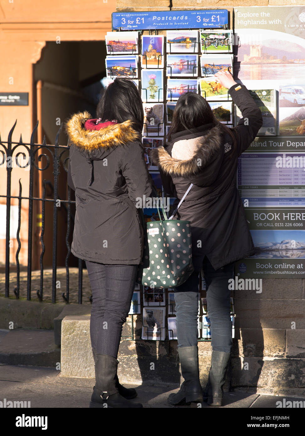 Dh Old Town de Edimburgo chica asiática turistas seleccionando postales turísticas de Escocia Foto de stock