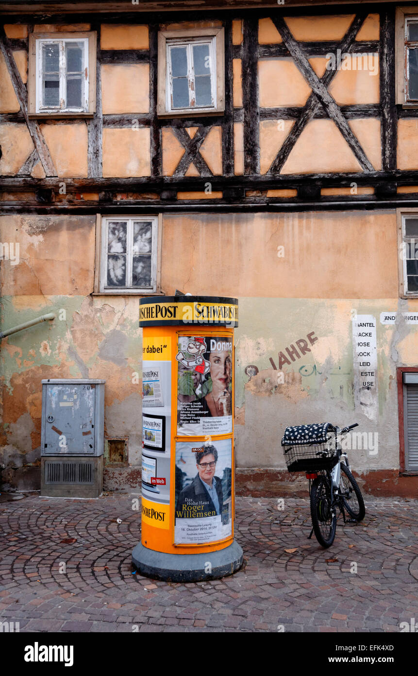 Junta y ciclo de publicidad con cesta fuera de un edificio de aspecto tradicional, con vigas de madera en Arlen, Alemania Foto de stock