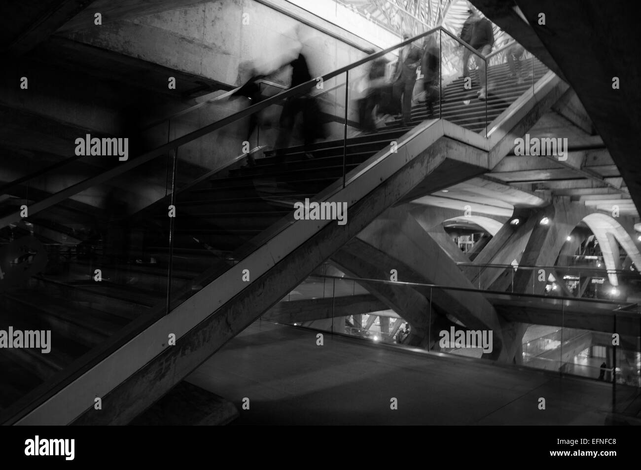 Fotografía en blanco y negro de gente borrosa downing las escaleras de una estación de tren Foto de stock
