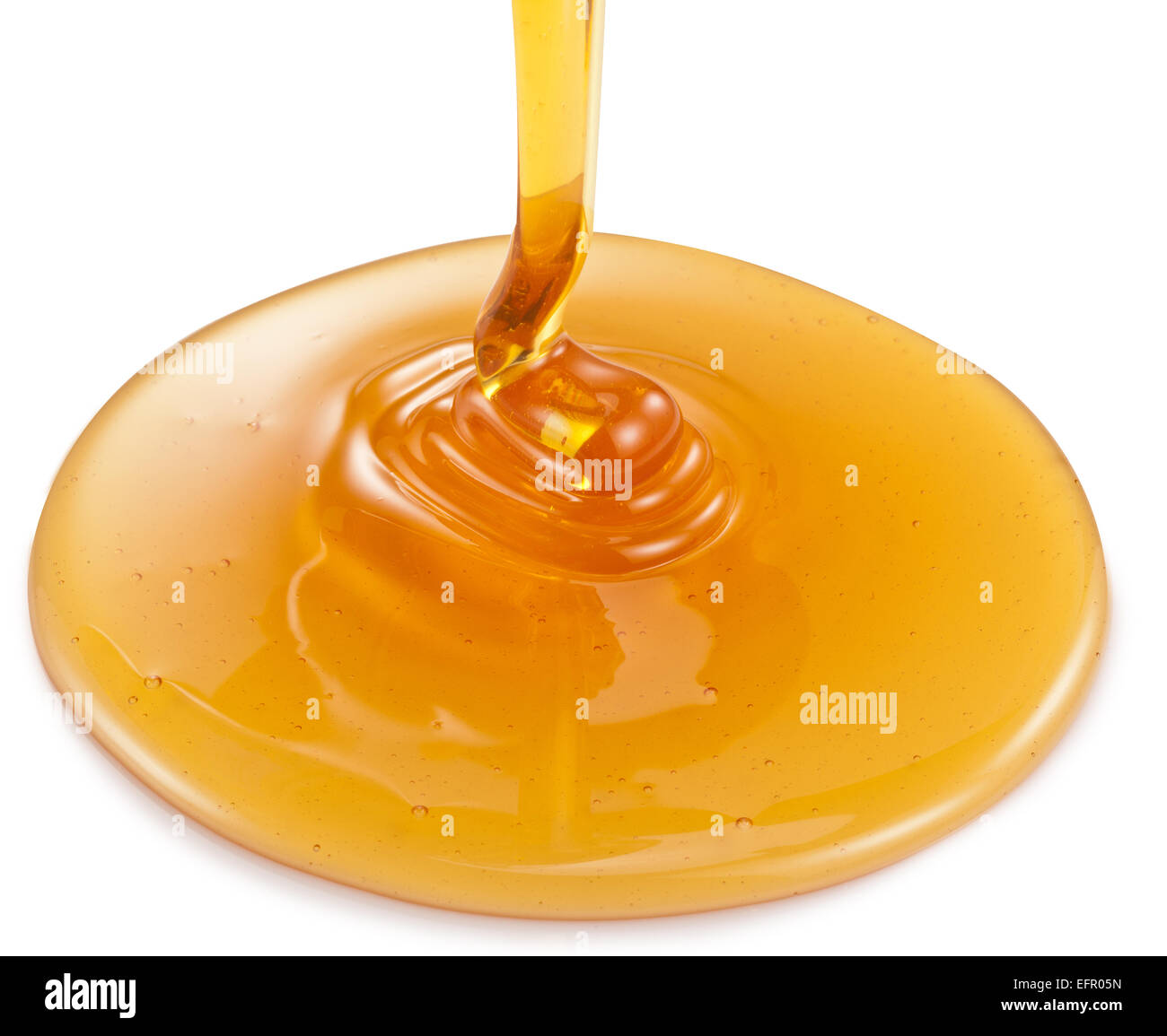 La miel que fluye sobre un fondo blanco. Los trazados de recorte. Foto de stock