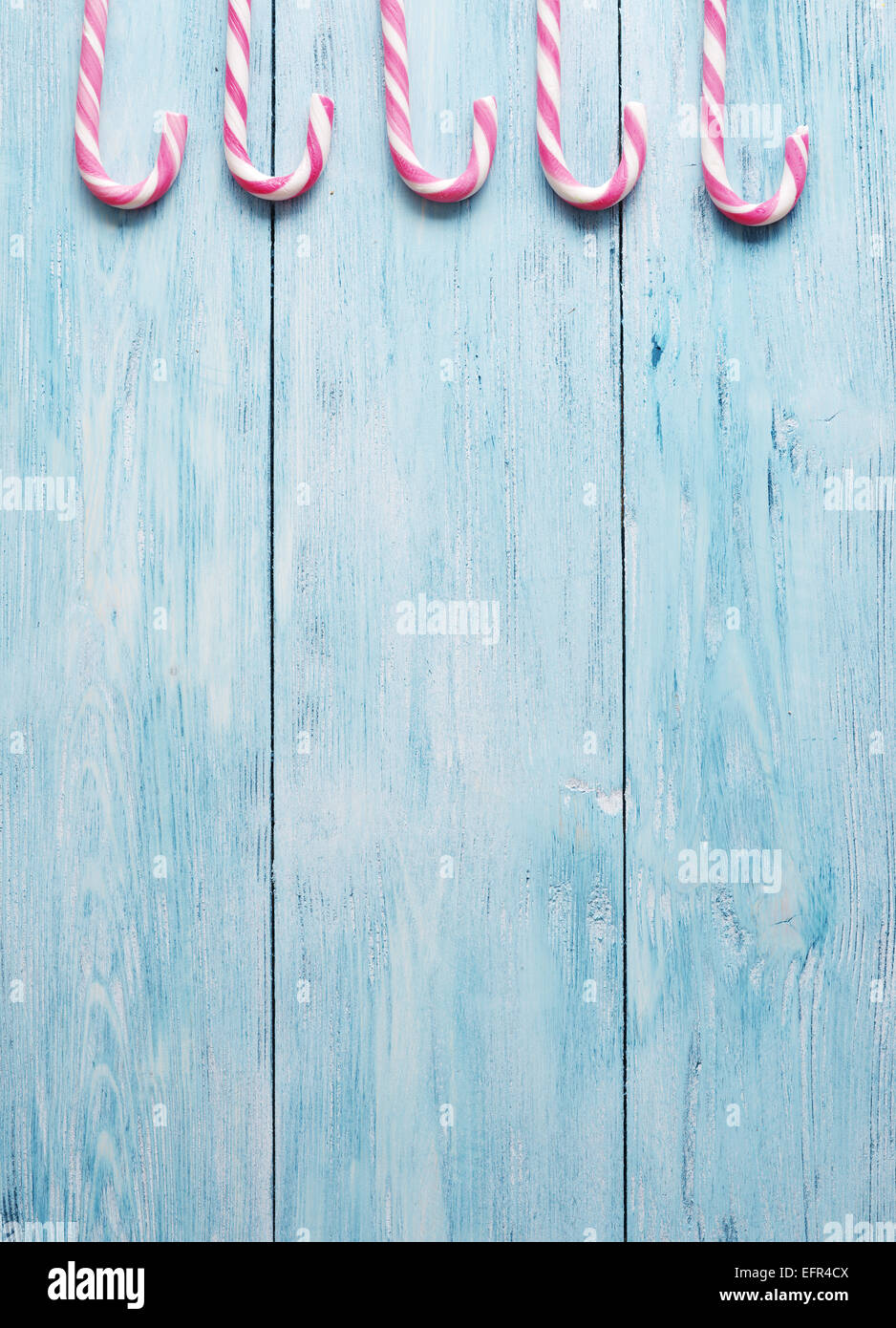 Bastones de caramelo sobre azul de fondo de madera. Foto de stock