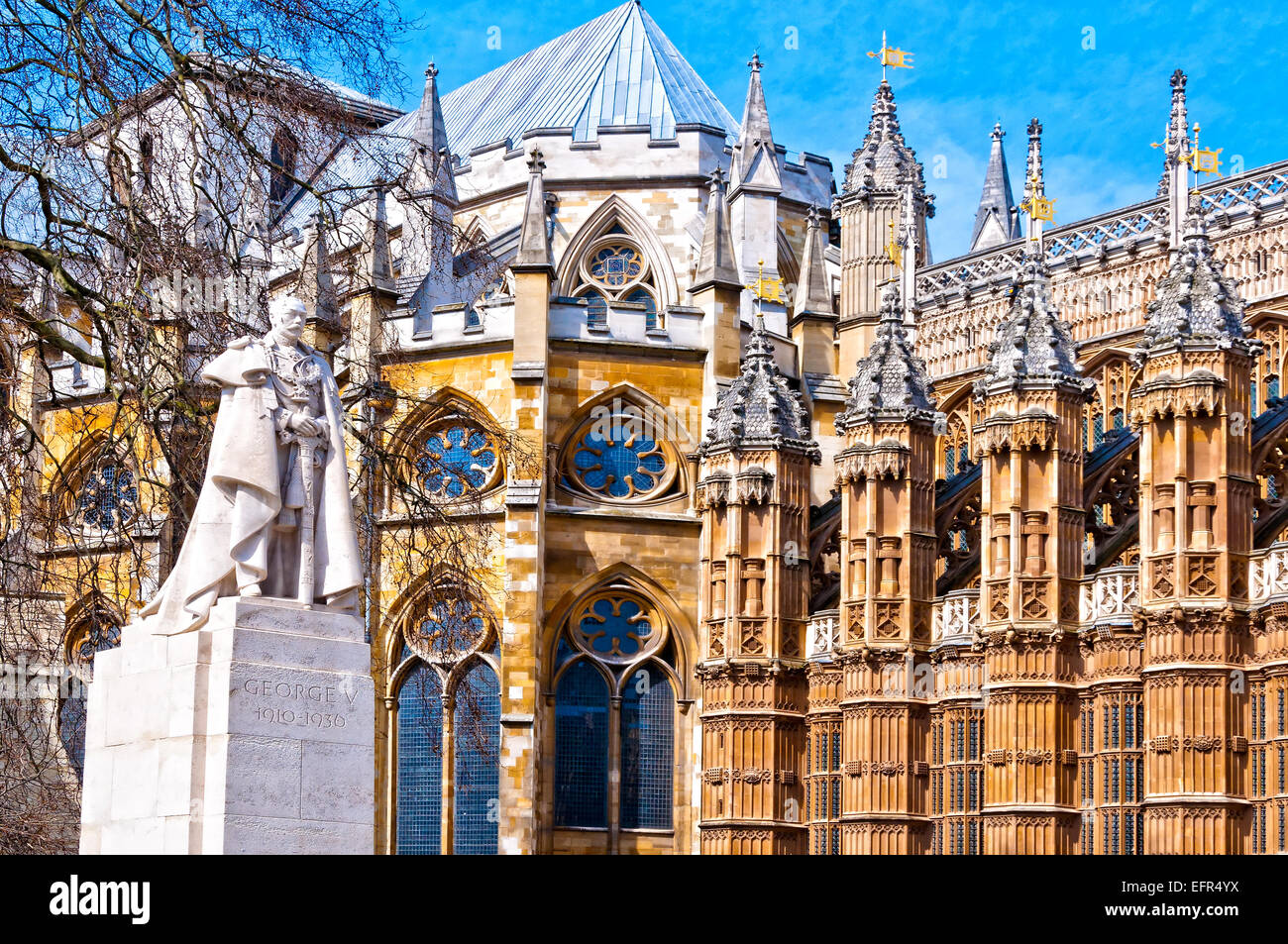 La estatua de George V y el detalle de la Abadía de Westminster, London Foto de stock