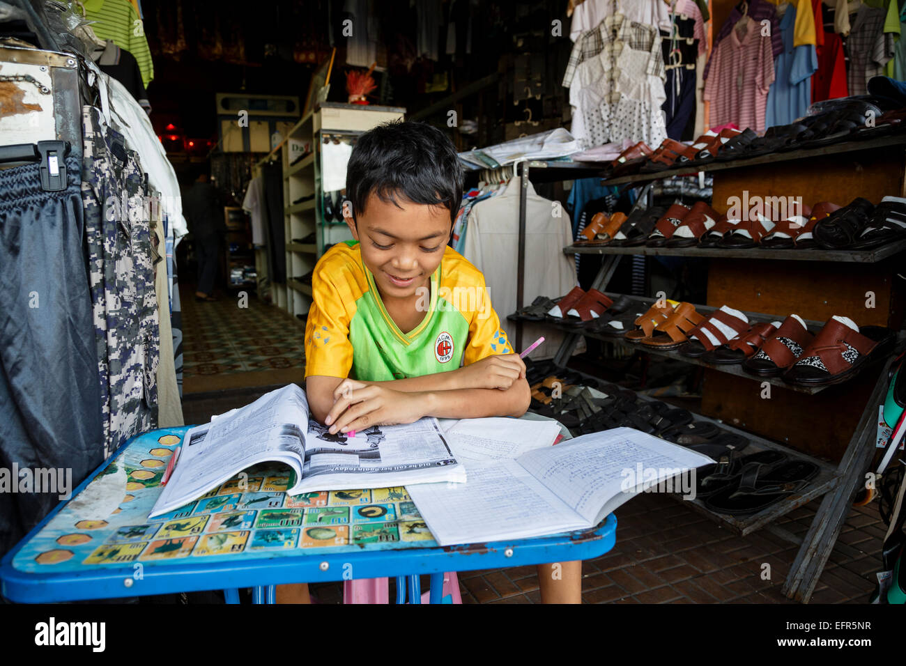 Chico haciendo sus deberes, en Phnom Penh, Camboya. Foto de stock
