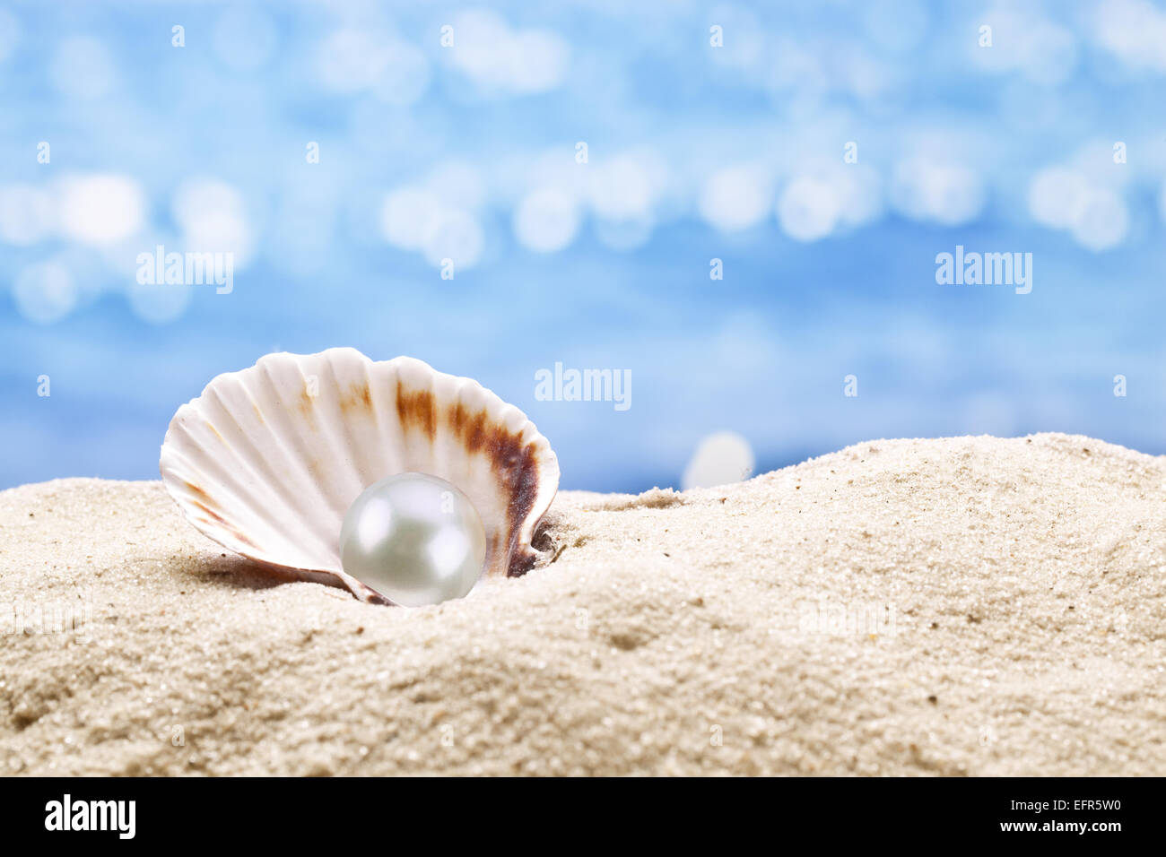 La ostra perla en la arena. Borrosa en el fondo del mar. Foto de stock
