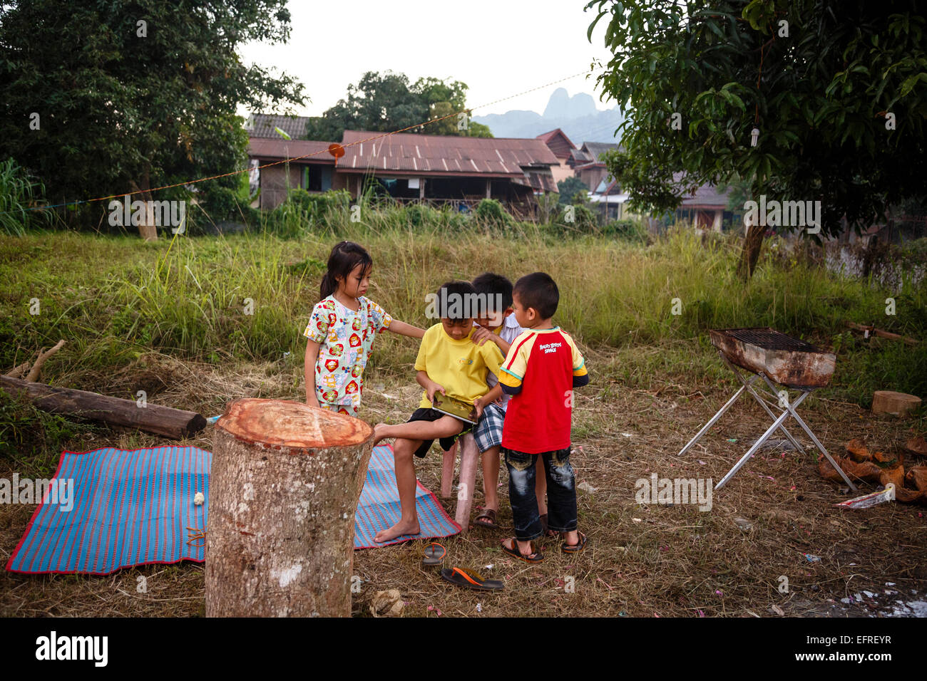 Los niños pequeños con un tablet, Vang Vieng, en Laos. Foto de stock