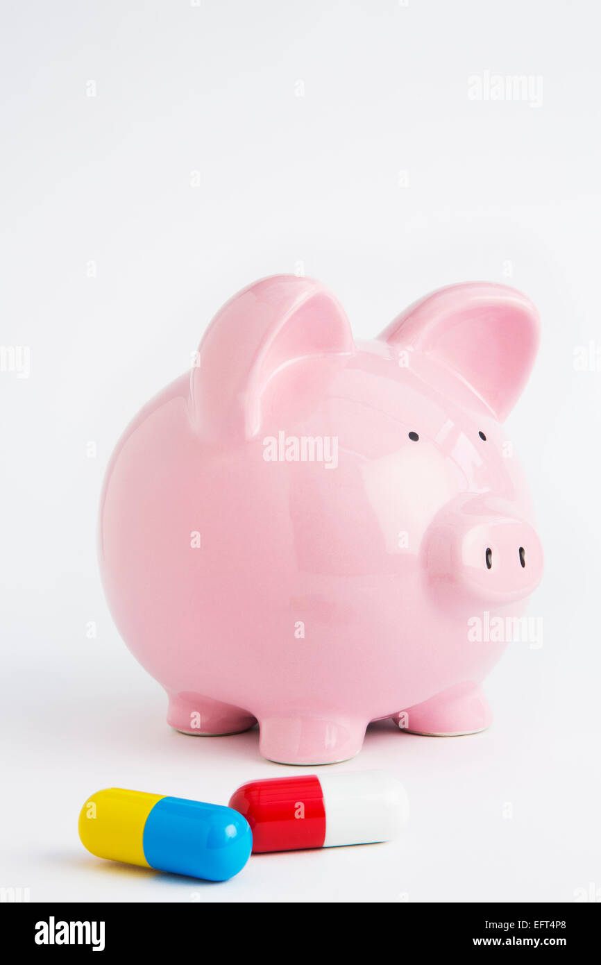 Caja de Ahorros con tabletas para ilustrar el seguro de salud Foto de stock