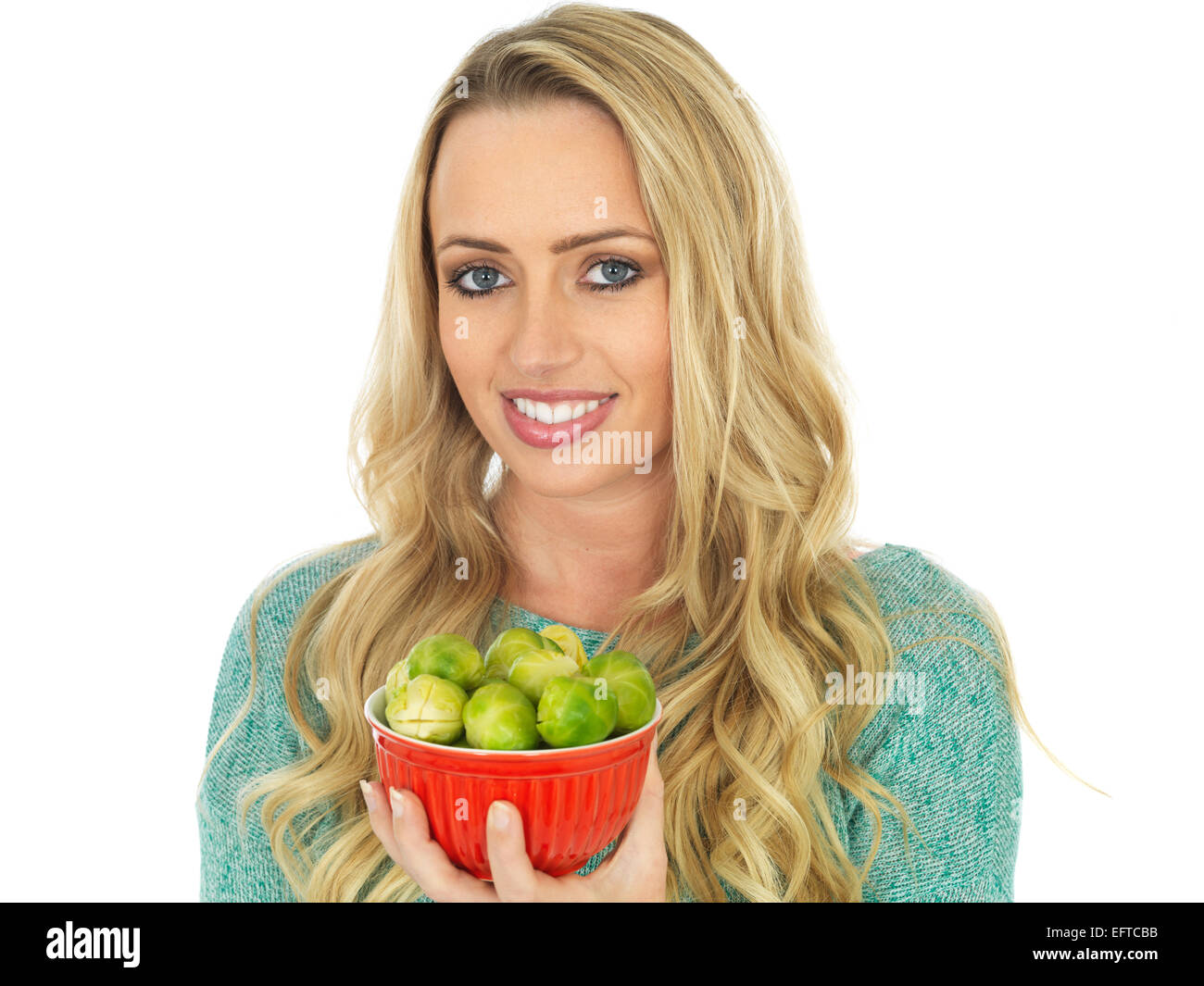 Atractiva mujer joven sosteniendo un cuenco de coles de bruselas Foto de stock