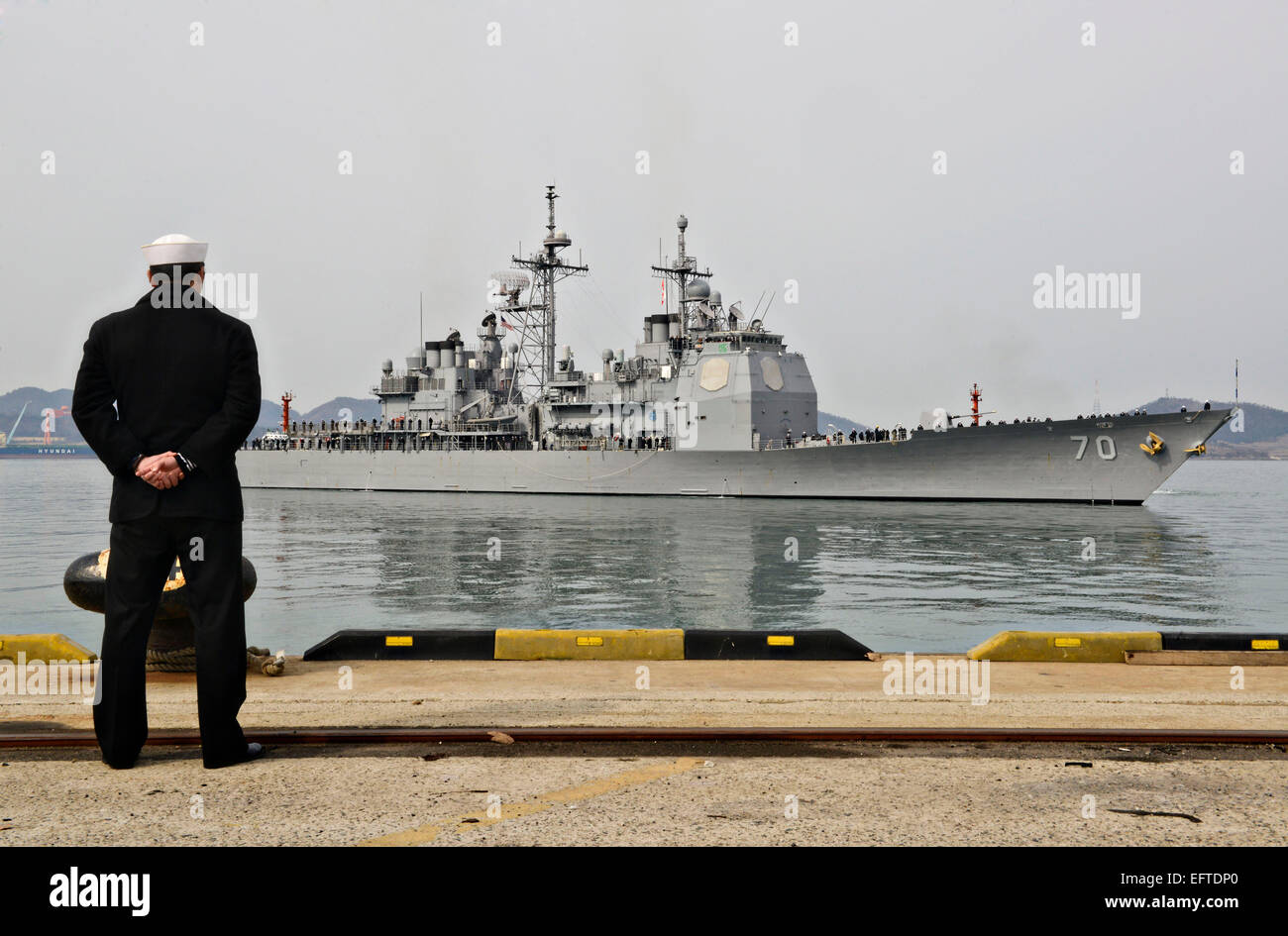 Una República de Corea marinero de la Marina de los EE.UU. Relojes de clase Ticonderoga guiado-crucero de misiles USS Lake Erie llega a un puerto Visita De marzo 8, 2013 en Mokpo, Corea del Sur. Foto de stock
