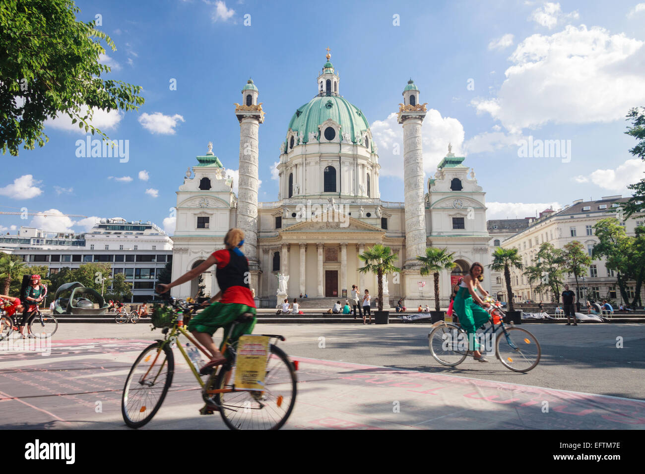 Los ciclistas por el Barroco Karlskirche, en Viena, Austria. Foto de stock