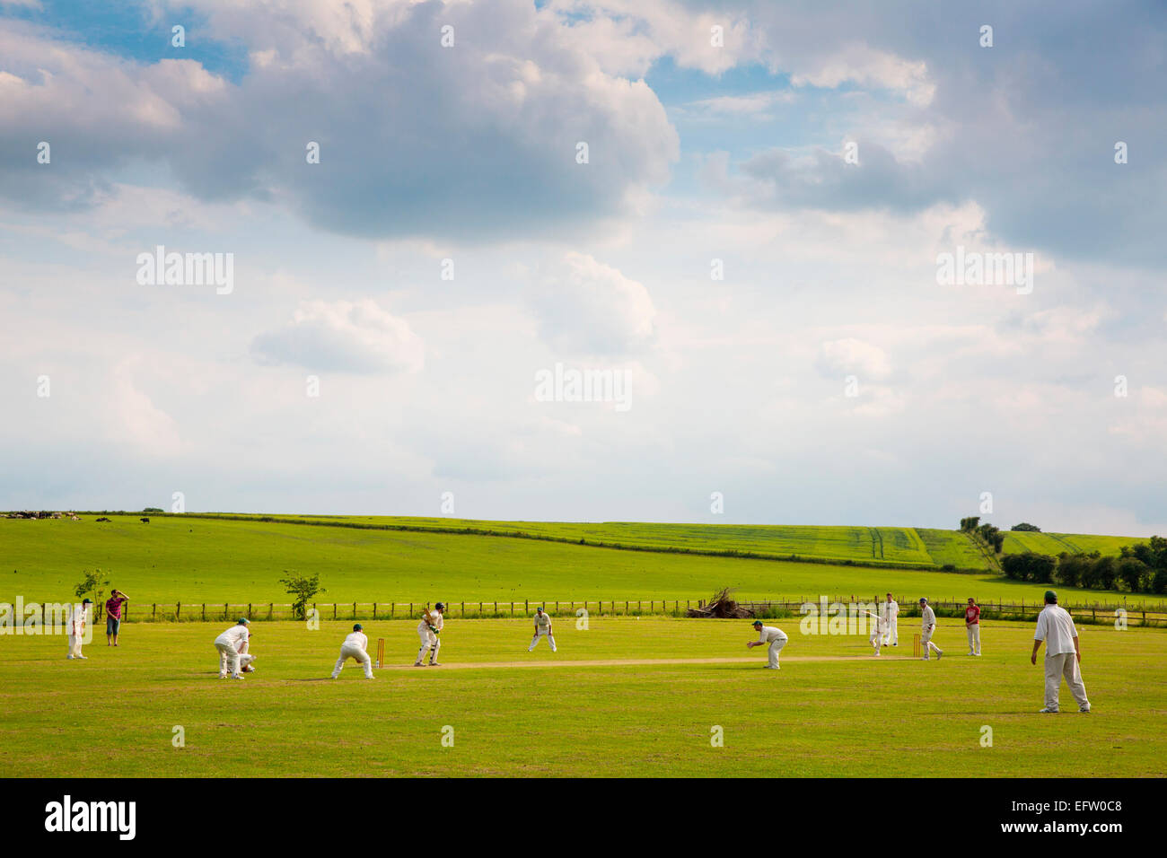 Escena rural con vistas jugadores de críquet jugando críquet coinciden en el campo de críquet Foto de stock
