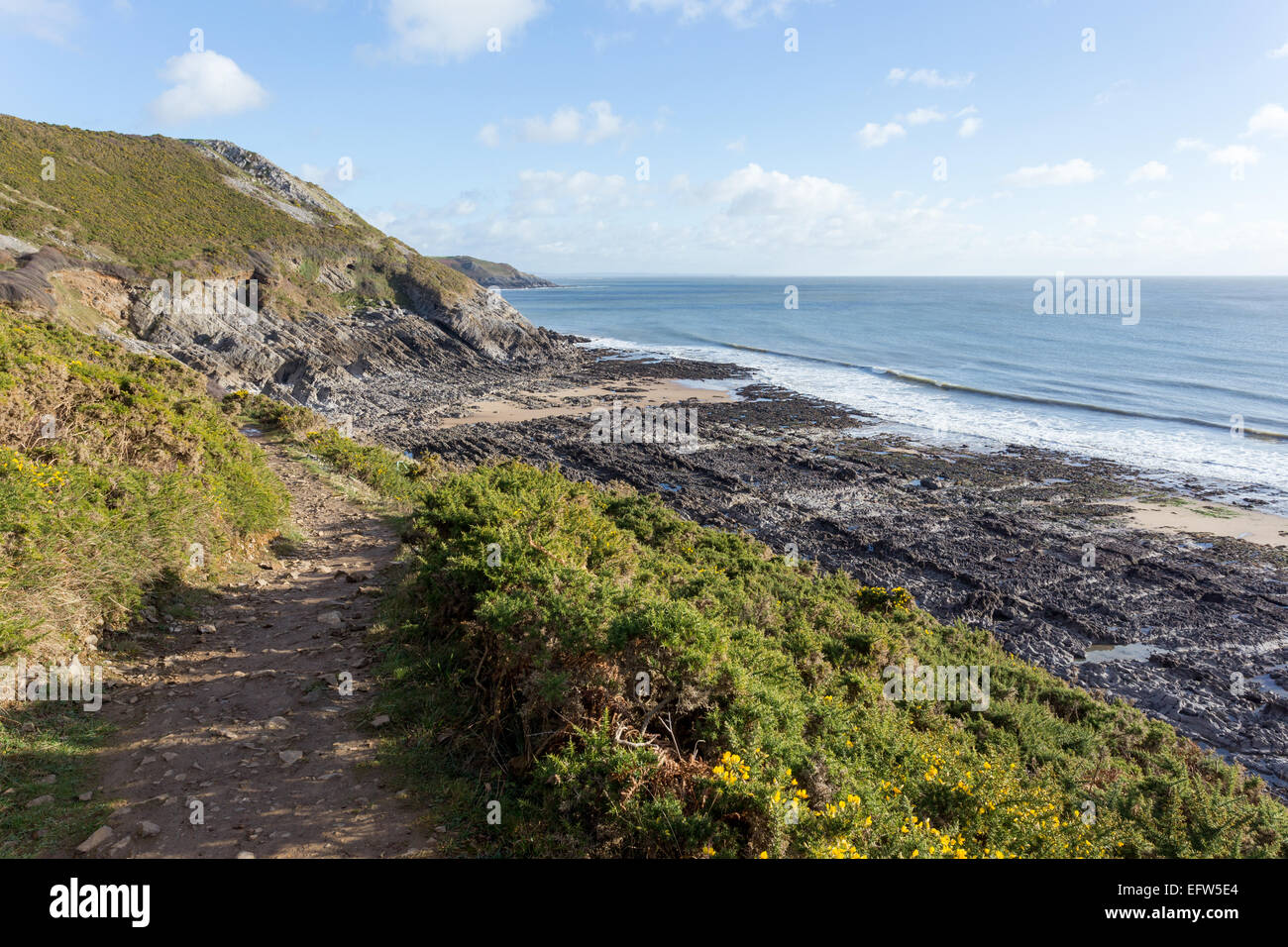 La piedra caliza carbonífera forma un pavimento de piedra caliza irregular en una playa al lado de la ruta de la costa de Gales, cerca de Caswell Bay, Gower. Foto de stock