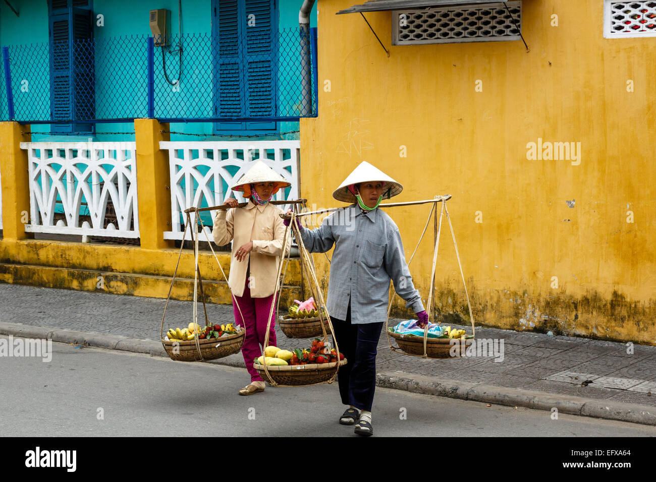 Las mujeres que llevan cestas, Hoi An, Vietnam. Foto de stock