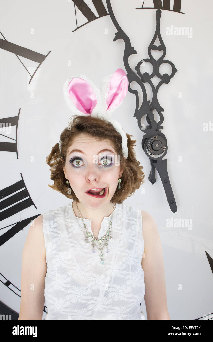 Mujer joven vestida como el personaje de conejo blanco de Alicia en el país  de las maravillas de pie en frente del reloj Fotografía de stock - Alamy