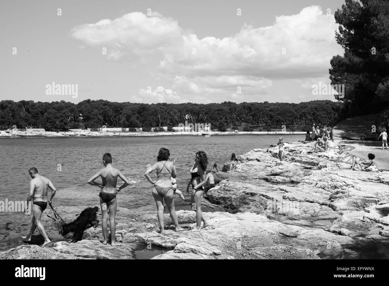 La gente en croata rocosa playa uno tan bien Foto de stock