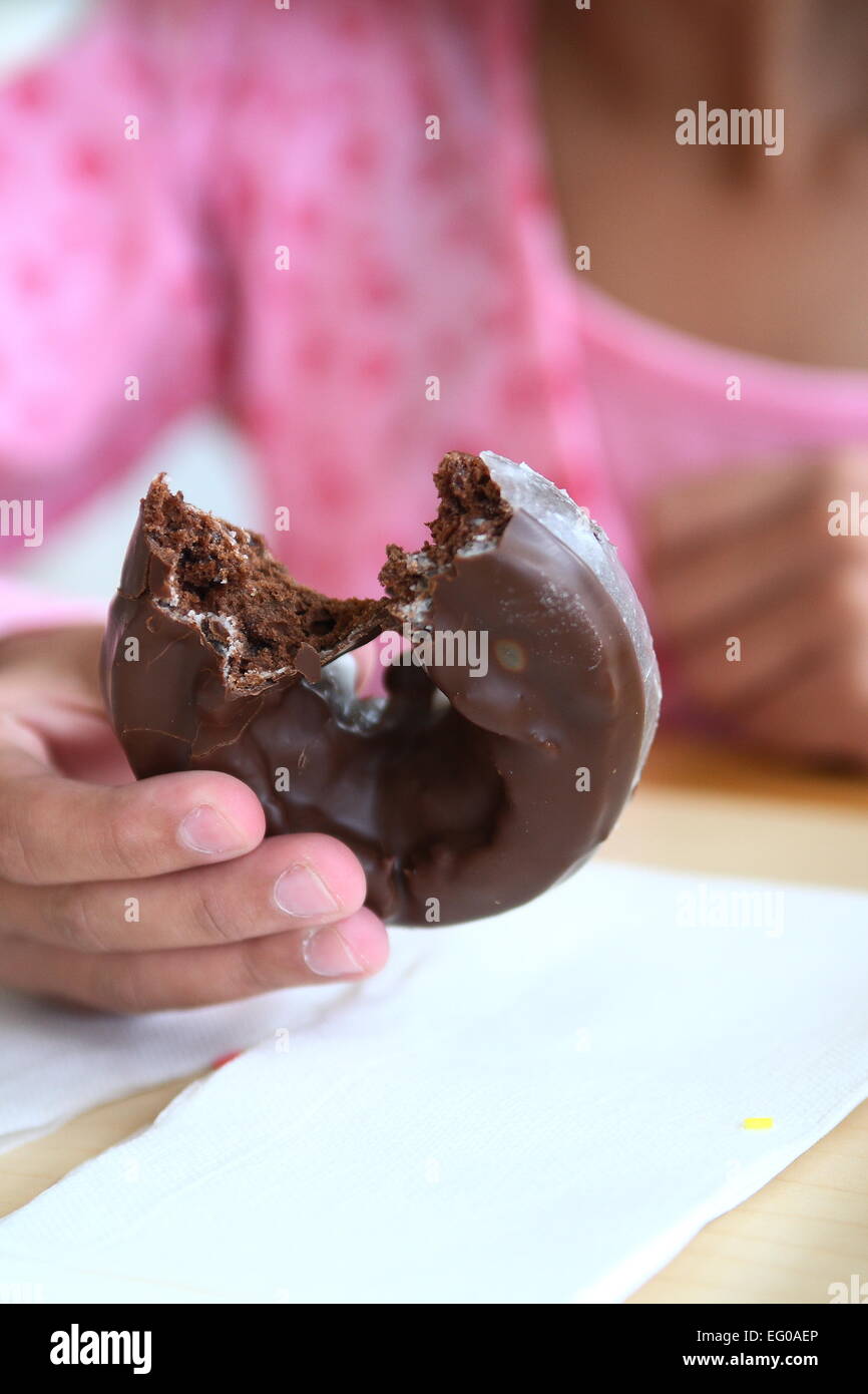 La celebración de donut de chocolate con una mordedura sacado Foto de stock