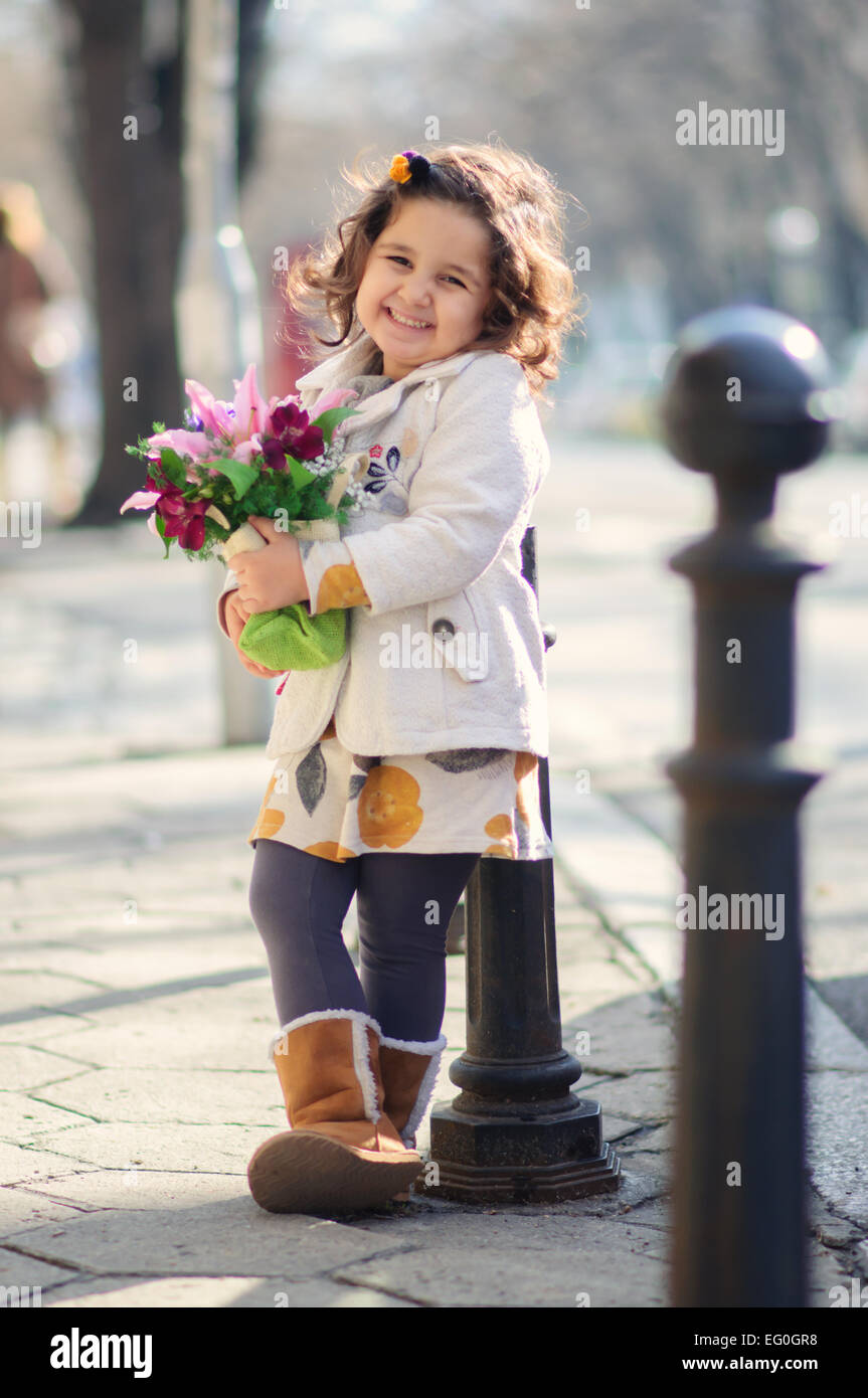 Niña pequeña (4-5) y sonriente sosteniendo bouquet Foto de stock