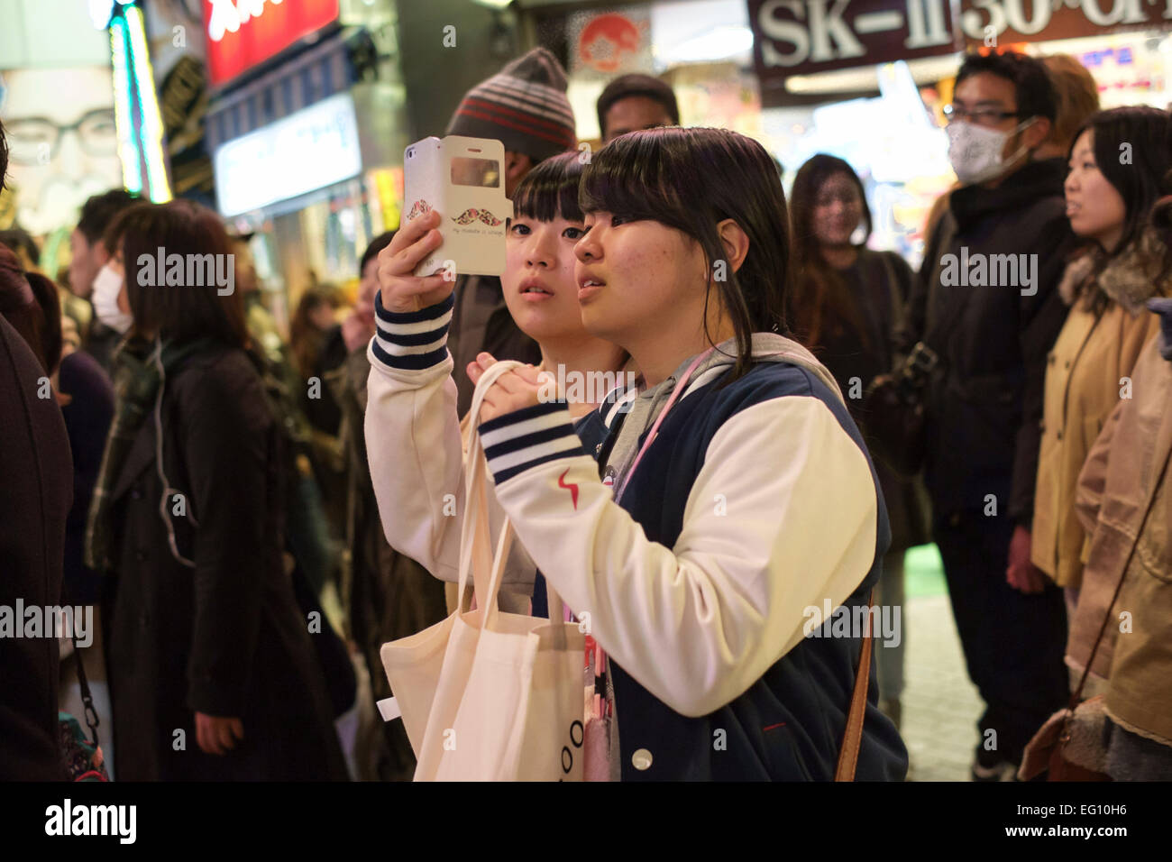 Las multitudes en la Sibuya cruce en frente de la estación de Shibuya. El cruce tiene la reputación de ser uno de los más concurridos del mundo. Conocido como la brega personas vienen de todas las direcciones a la vez cuando las luces cambian. Tokio, Japón. Foto de stock