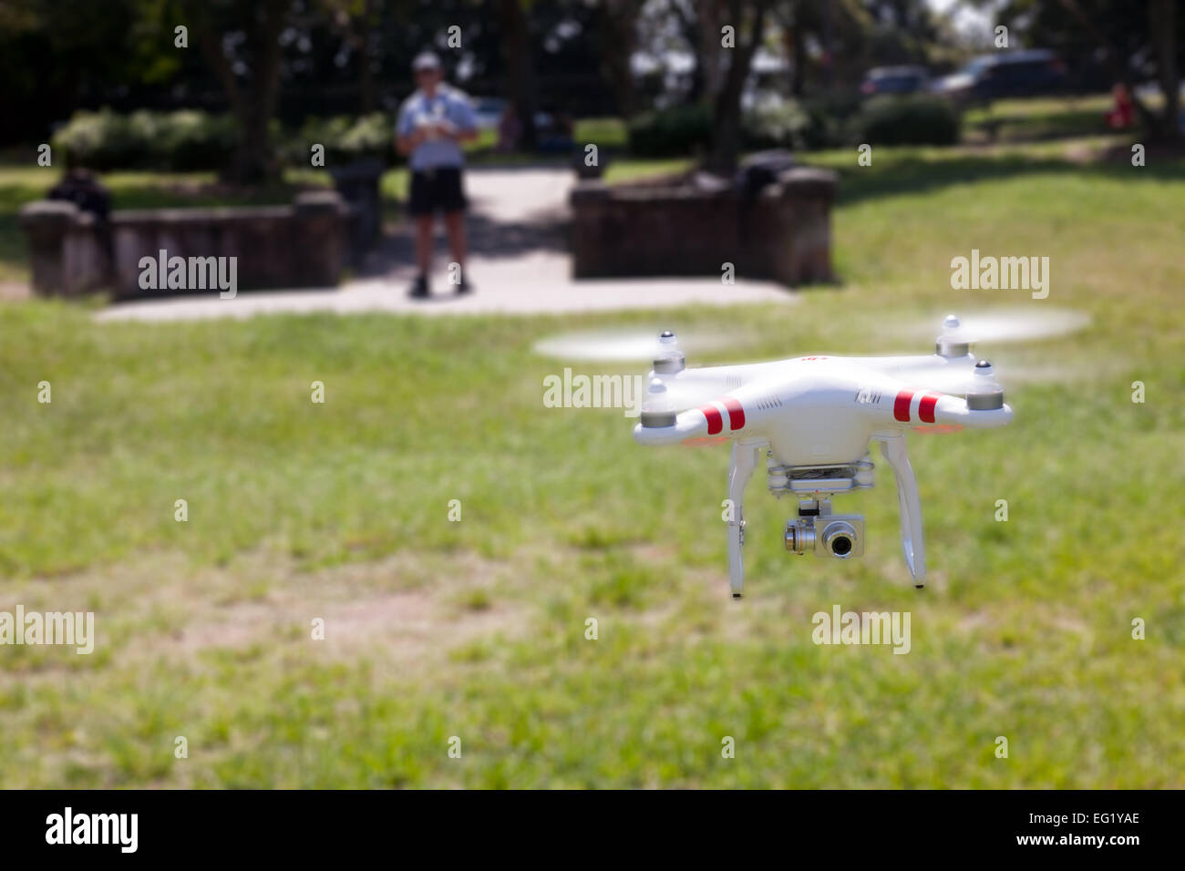 Un vuelo de drone con un gimbal y cámara conectada. Con el fotógrafo en el fondo. Foto de stock