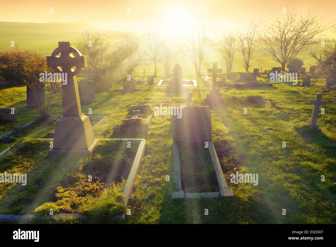 Luz celestial brilla sobre un antiguo cementerio en Inglaterra, Reino Unido. Foto de stock