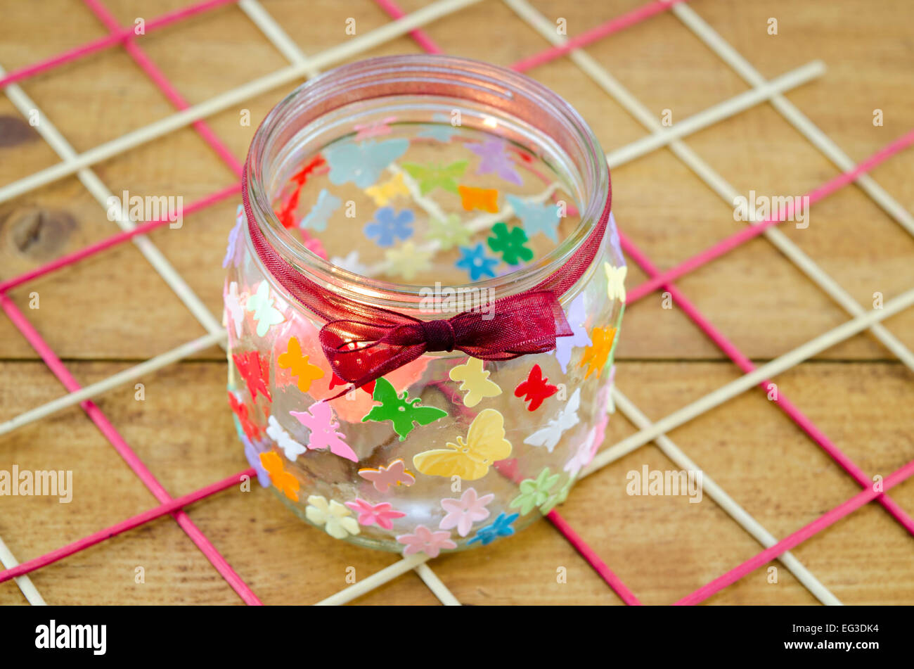 Bricolaje candelabro decoradas con coloridas mariposas en una mesa de madera Foto de stock