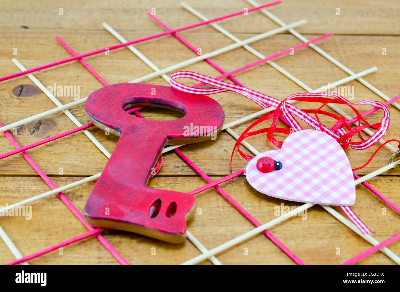 Disposición romántica para San Valentín incluye una tecla roja y un corazón sobre una tabla de madera decoradas Foto de stock