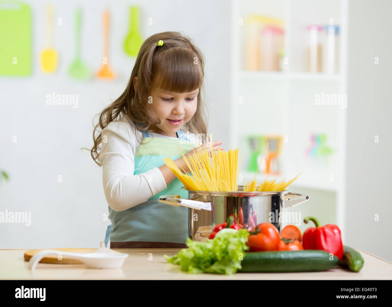 Chico Chica jugando a cocinar y preparar espaguetis Foto de stock