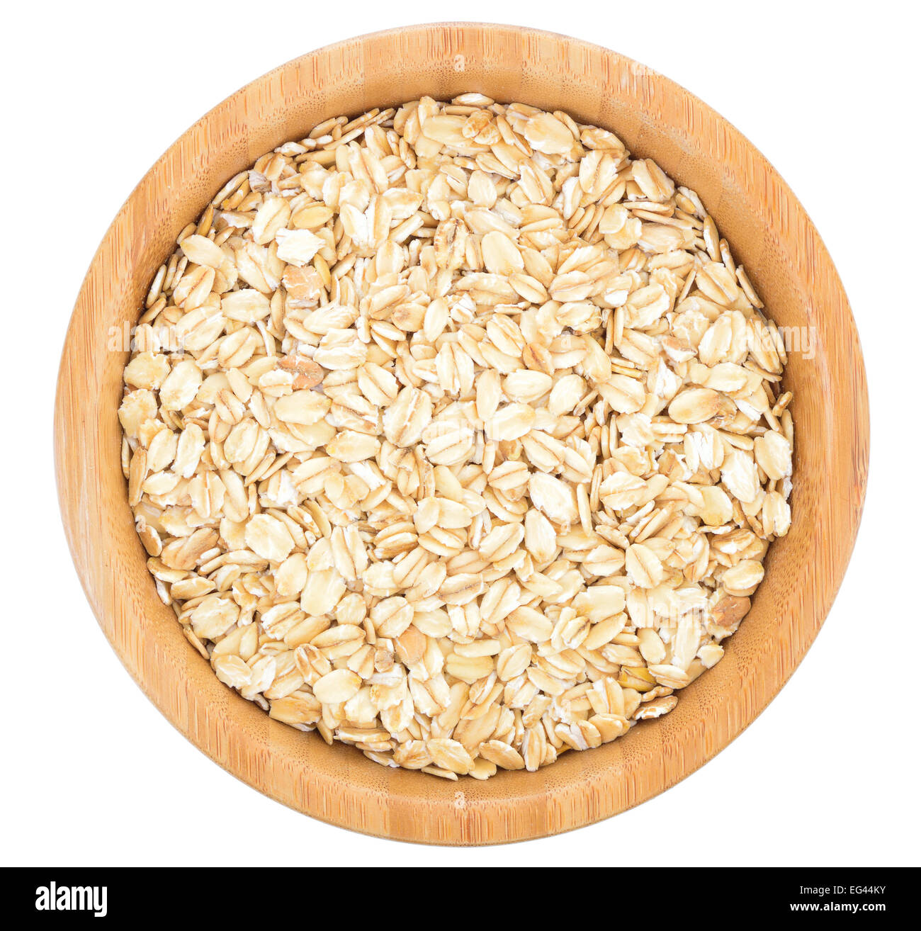 Los copos de avena en el tazón de madera aislado sobre fondo blanco. Foto de stock