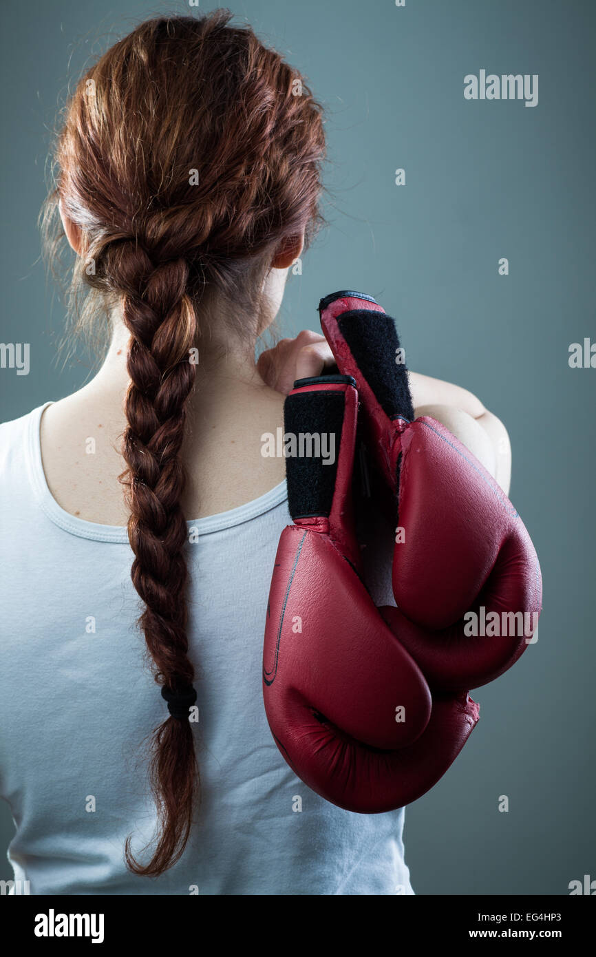 Mujer con trenza celebrar dos guantes de boxeo Foto de stock