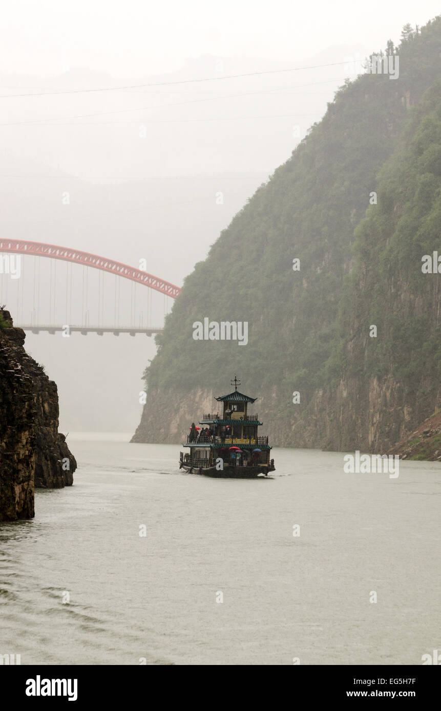 Misty desfiladero con un crucero por el río barco chino y el nuevo Dragon Gate Bridge, Wushan, China Foto de stock