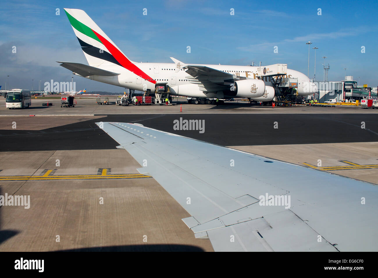 Bmi Regional Embraer 145 taxis pasado un Airbus A380 de Emirates en el aeropuerto de Manchester. Foto de stock