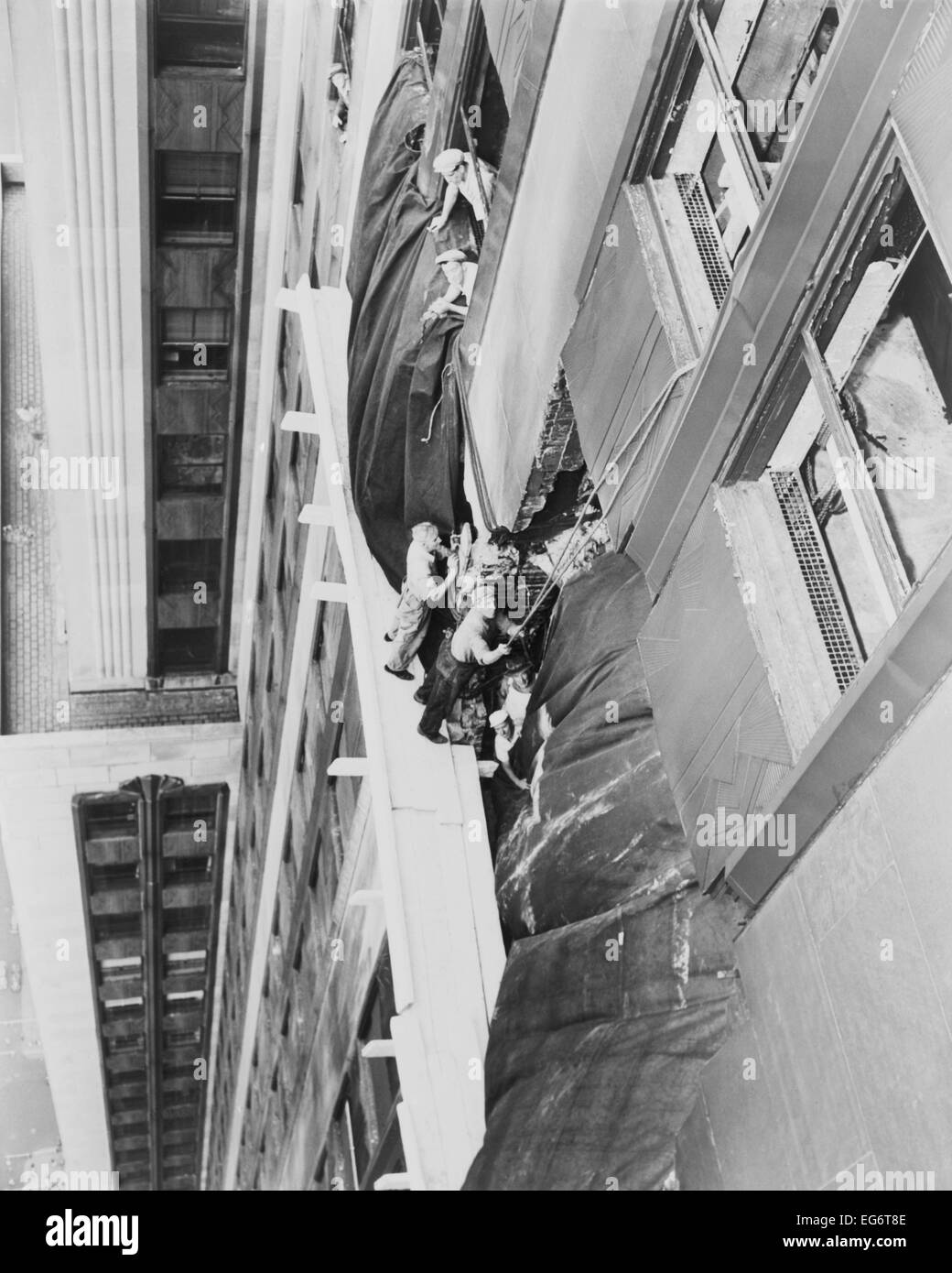 Obreros coloque un lienzo sobre el orificio entre la 78ª y 79ª plantas del  edificio Empire State. Un bombardero B-25 Mitchell se estrelló Fotografía  de stock - Alamy