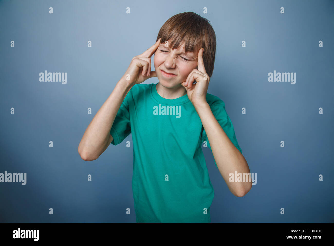 Unión-mirando a un niño de diez años, dolor de cabeza, la migraña en un gris Foto de stock