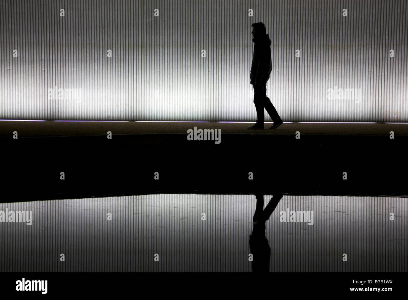 Hombre solitario caminando debajo de un puente/túnel Foto de stock
