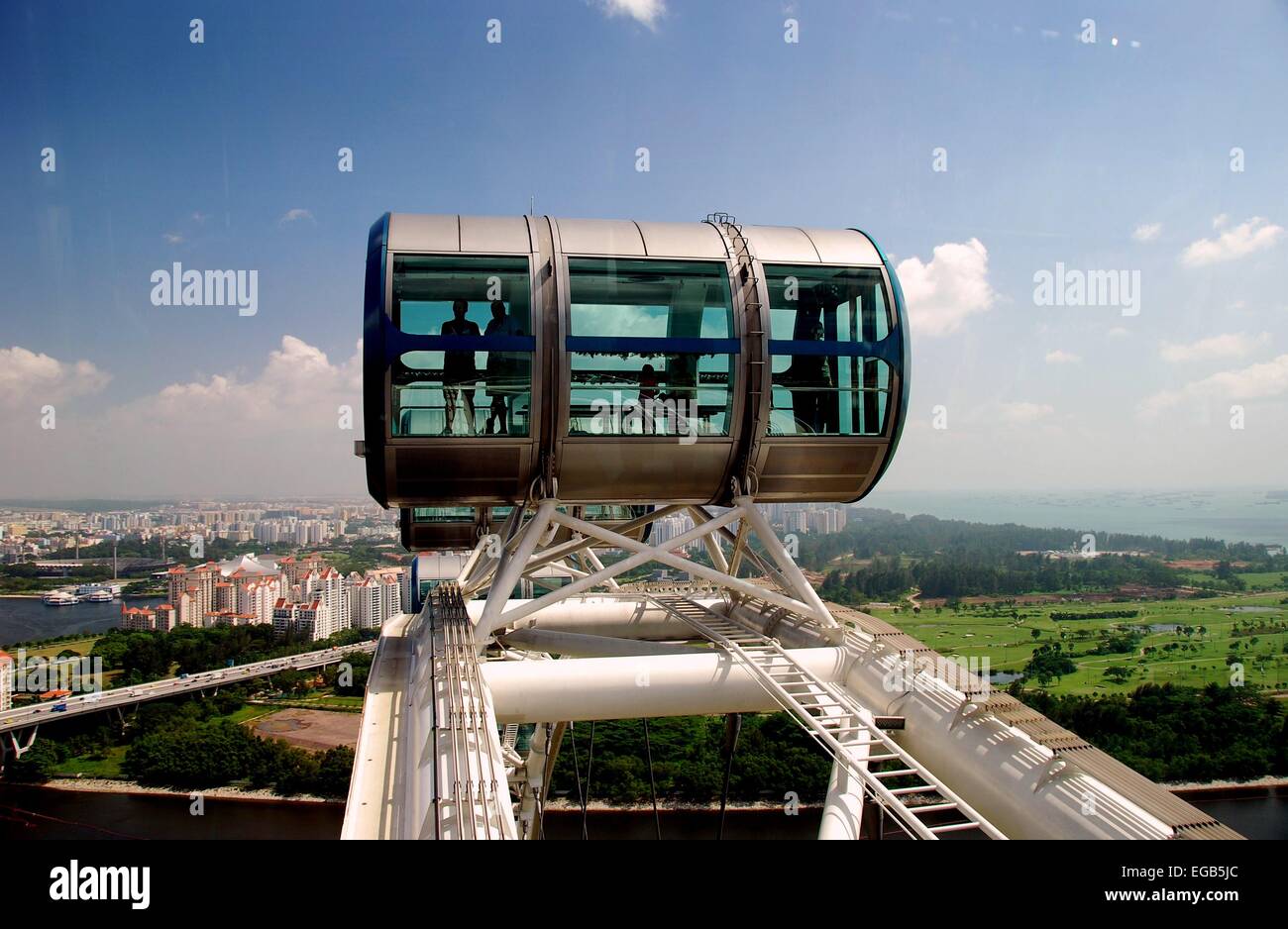 Singapur : Los pasajeros viajan en una de las góndolas en la cima de la enorme noria Singapore Flyer Foto de stock
