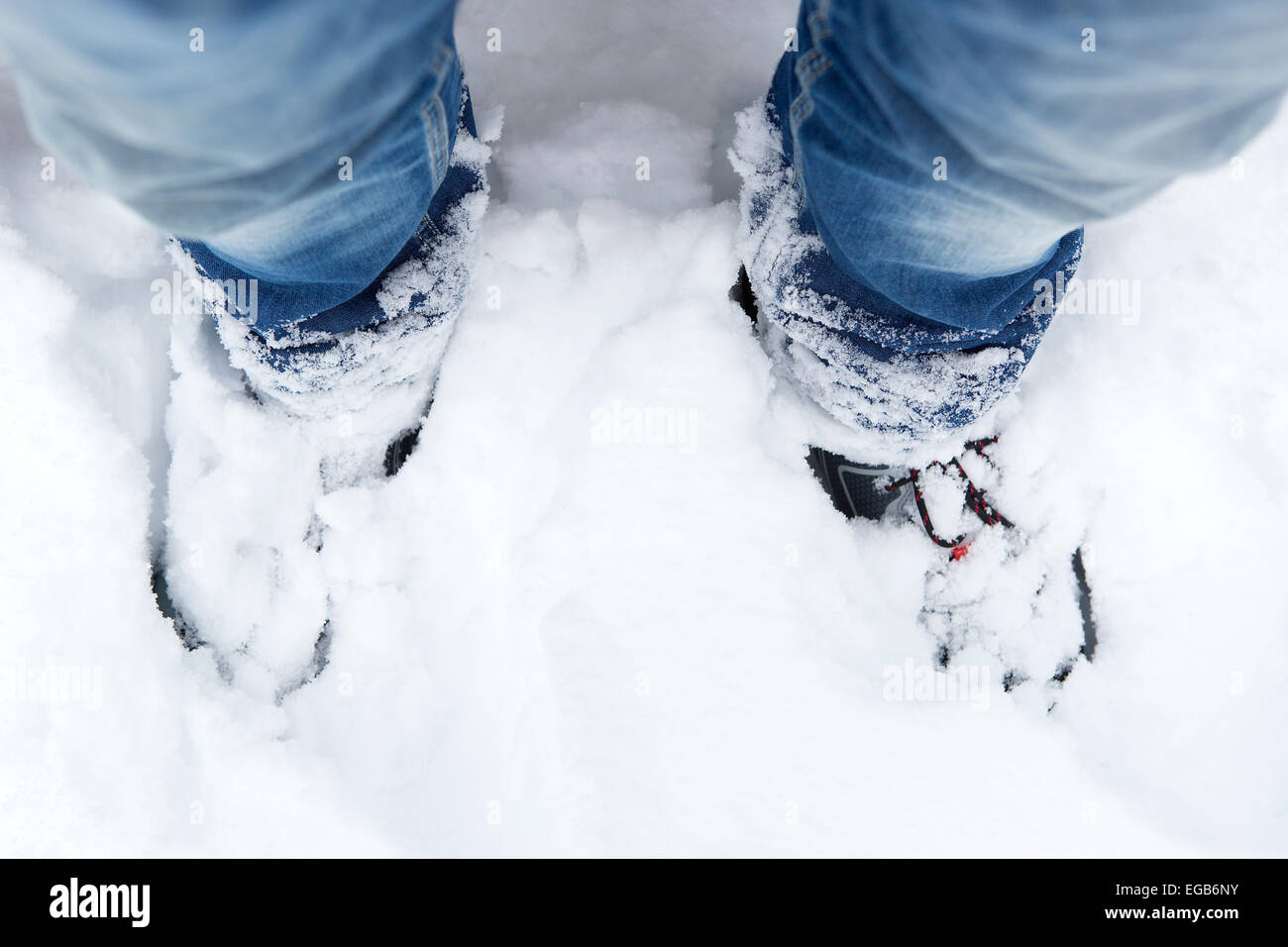 Primer plano de una montaña nevada zapatos y blue jeans Foto de stock
