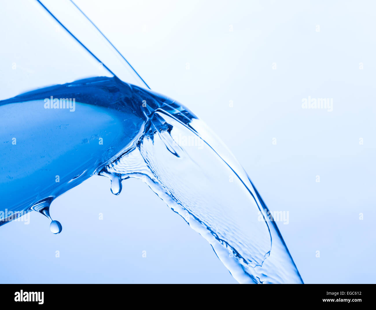 Verter agua fría de una copa de cristal transparente, cerrar Foto de stock