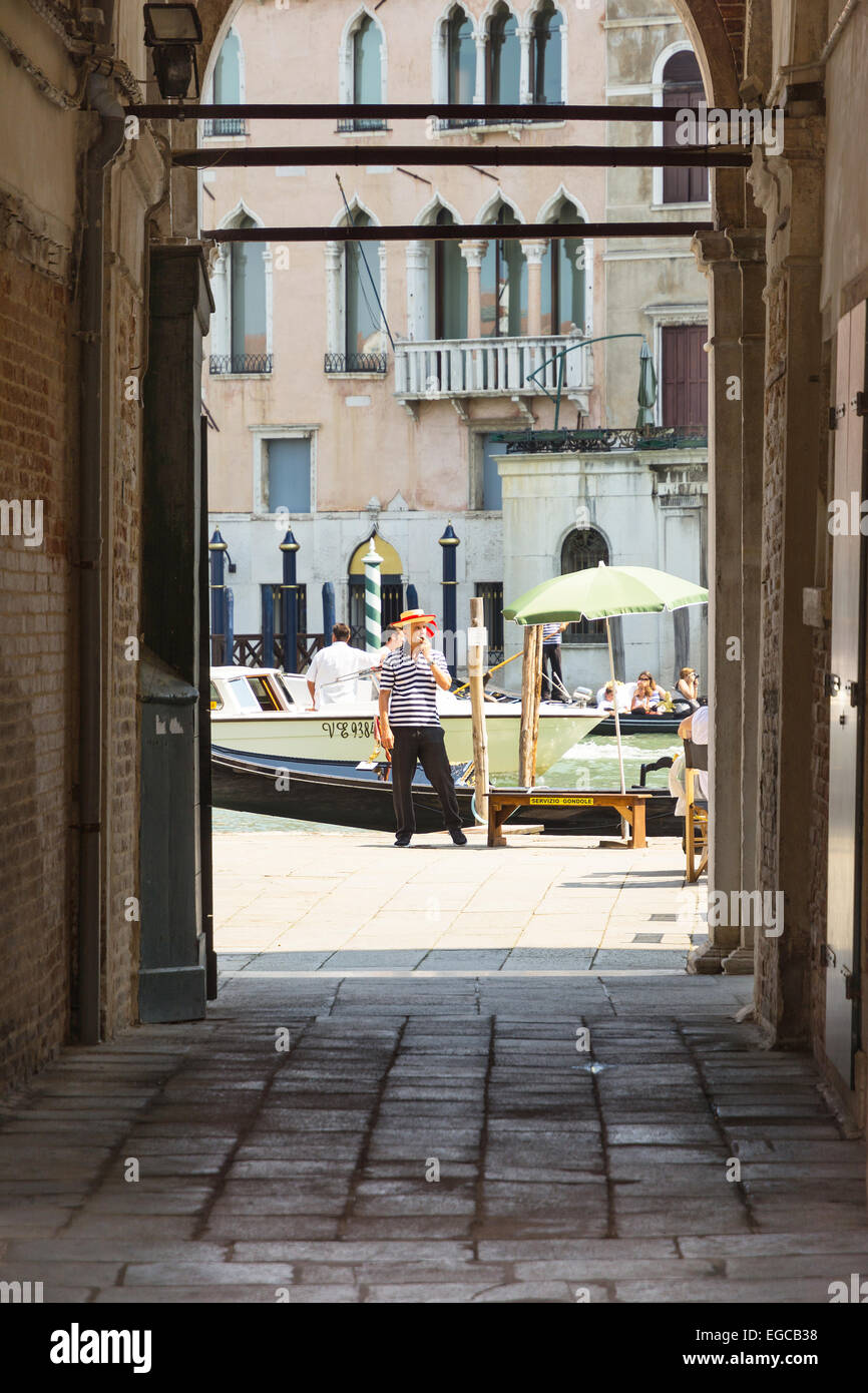Venecia,Italy-August 12,2014:un gondolero esperando algún turista a llevar alrededor del canal de Venecia durante un día soleado Foto de stock