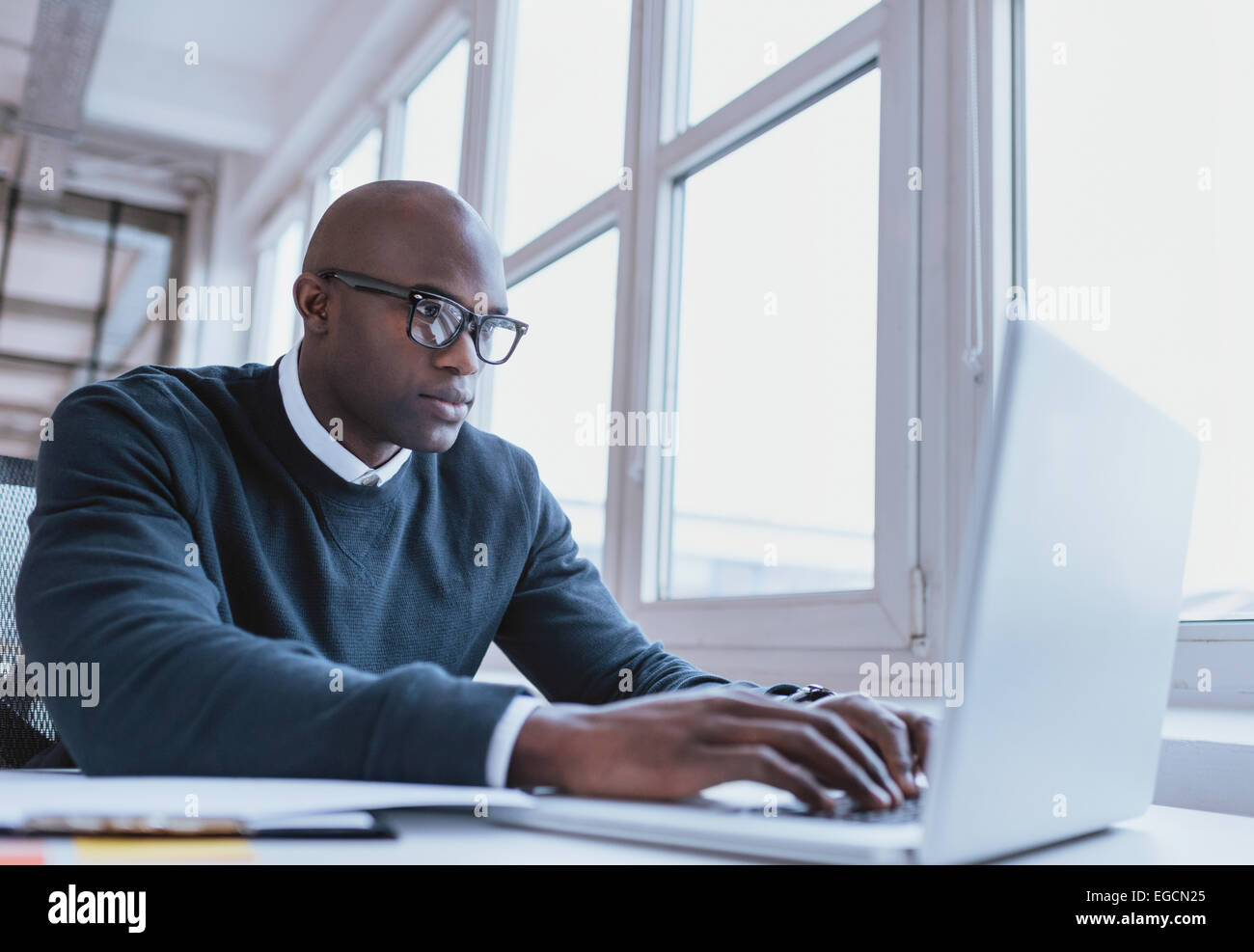 Imagen del empresario americano africano trabajando en su portátil. Apuesto joven en su escritorio. Foto de stock
