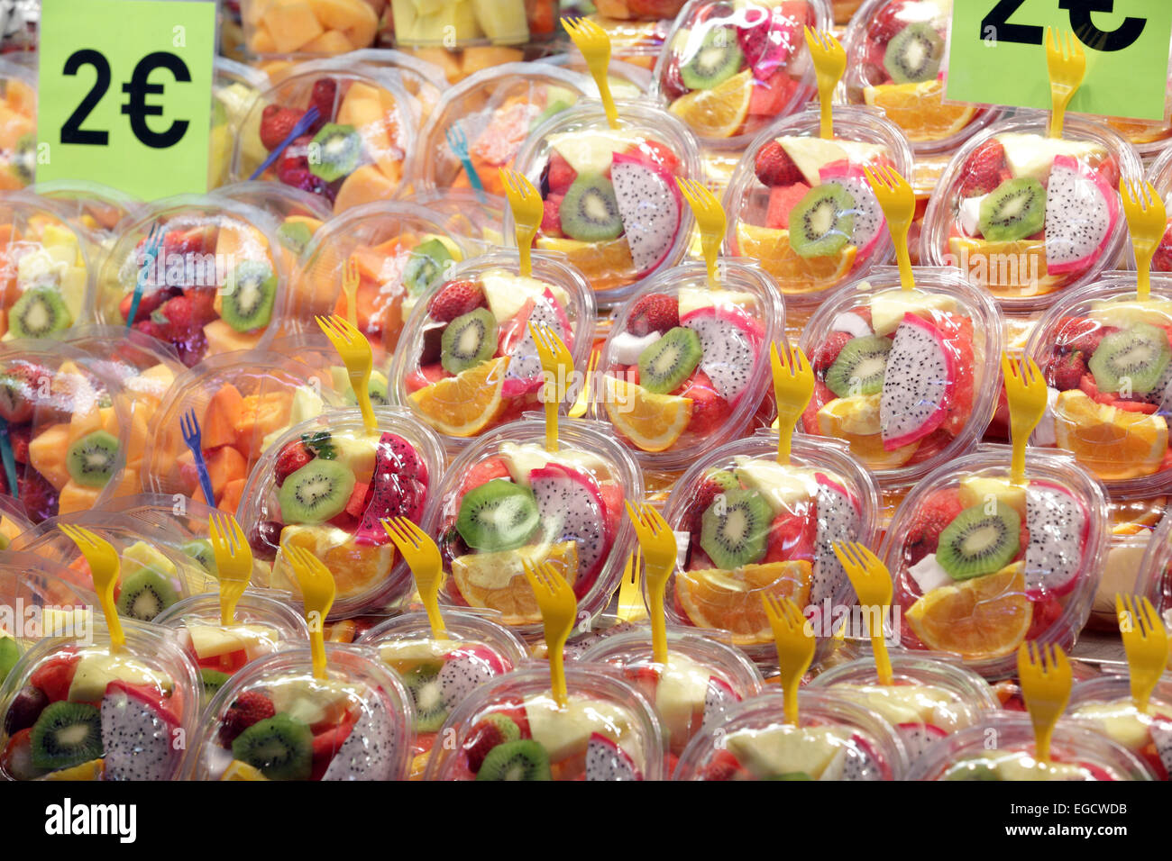 Vistosamente coloridas ensaladas de fruta fresca y saludable para la venta en el mercado de alimentos, la Rambas, Barcelona, España Foto de stock