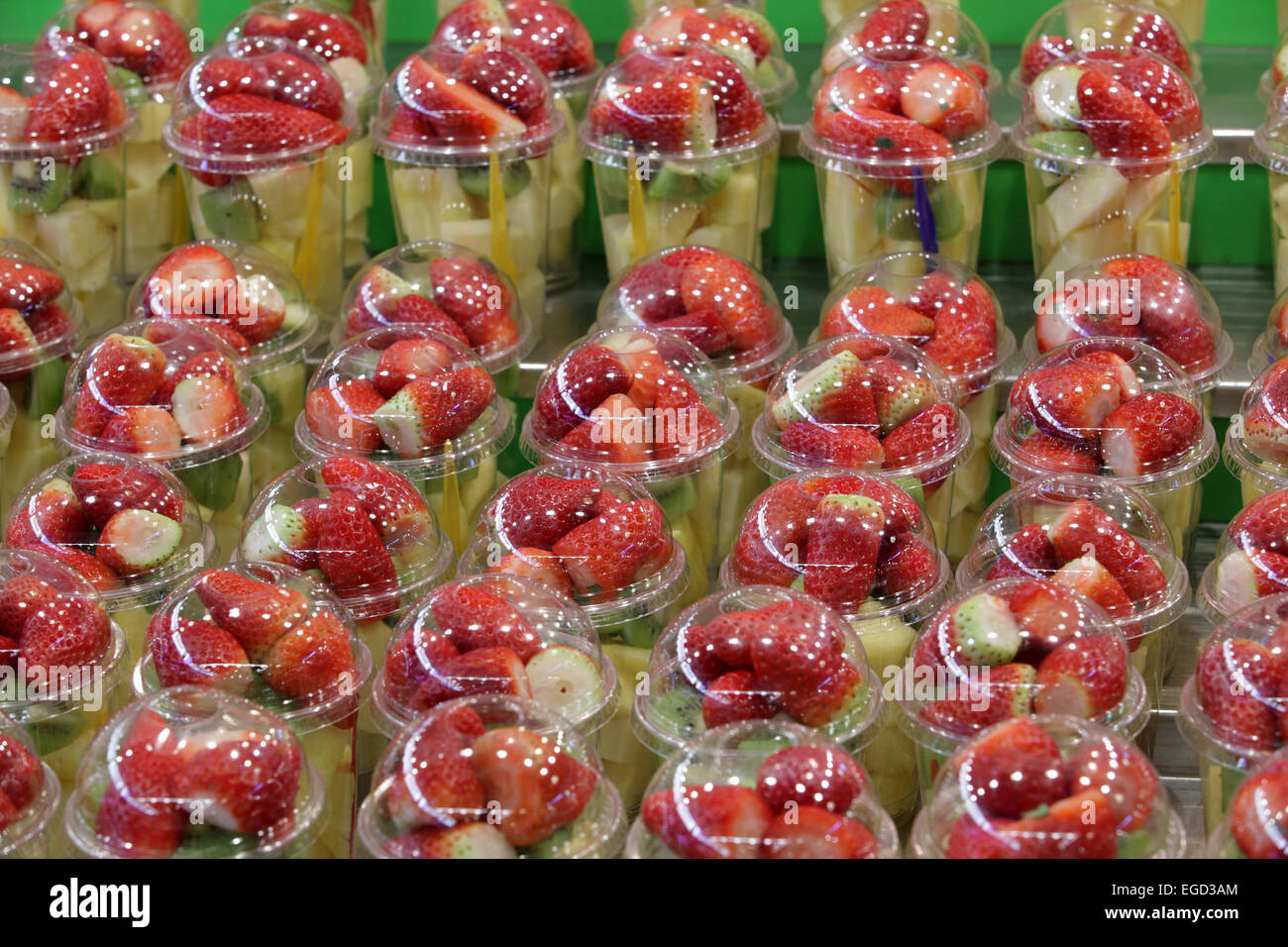 Vistosamente coloridas ensaladas de fruta fresca y saludable para la venta de alimentos en el mercado de la Boqueria, La Ramba, Barcelona, España Foto de stock